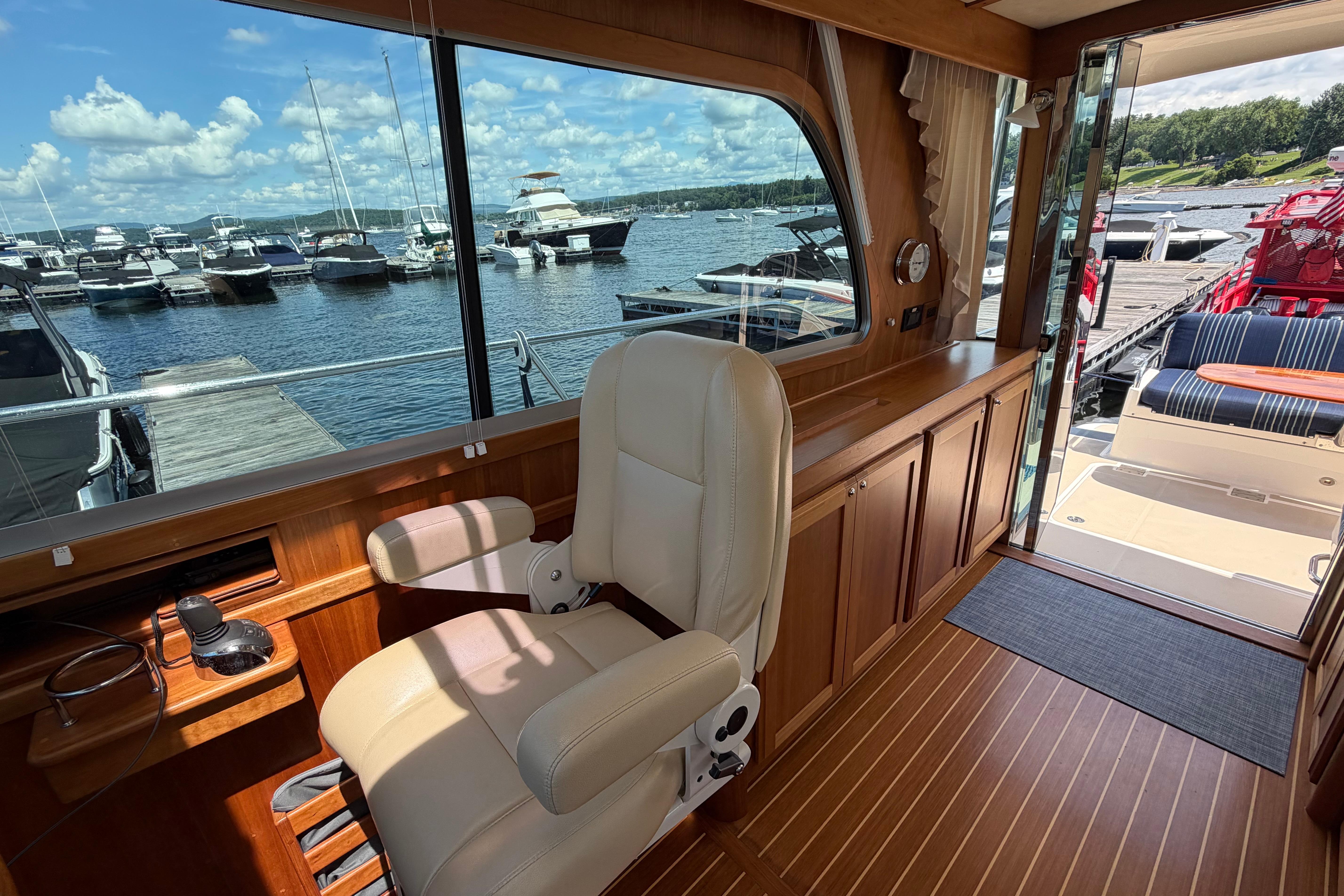 Interior of 2015 Sabre 38 Salon Express yacht with marina view through large windows.