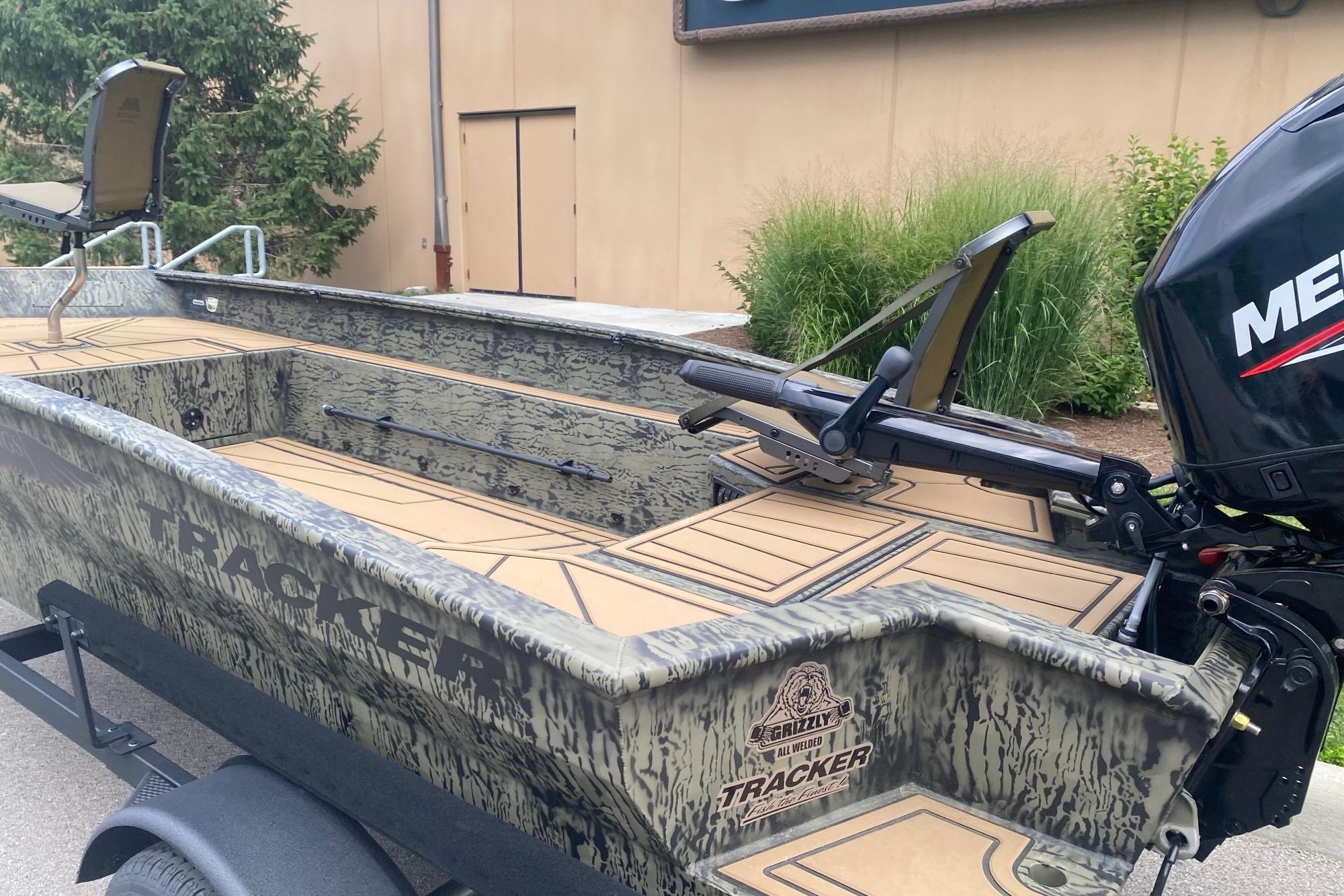 2026 Tracker Grizzly 1650 T Prairie Wings Edition boat with camouflage design and Mercury outboard motor.