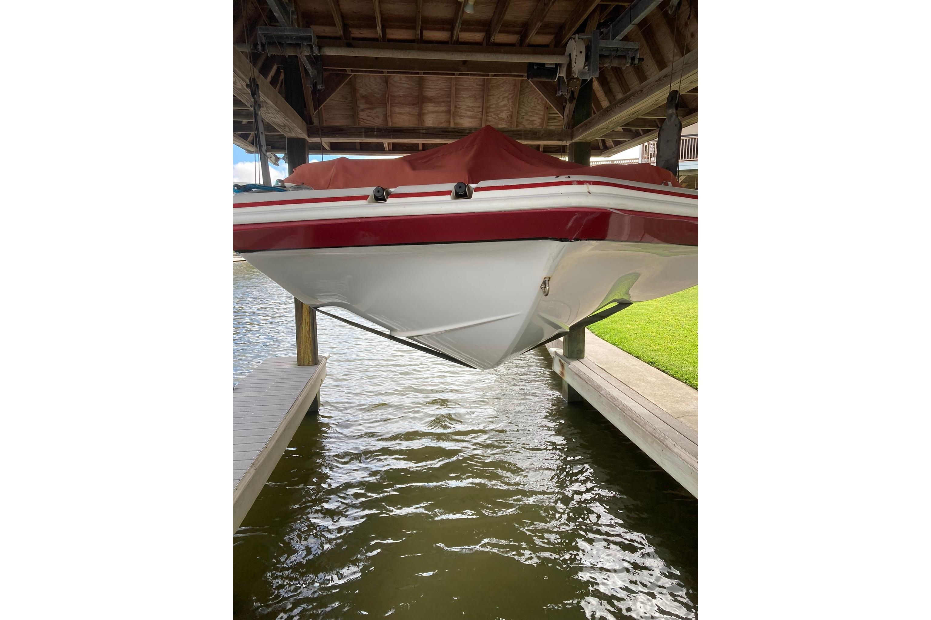 2013 Hurricane SunDeck Sport 201 OB boat docked under a covered structure.