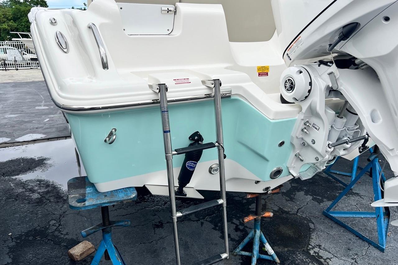 2026 Key West 239 FS boat on stands, featuring a swim ladder and outboard motor.