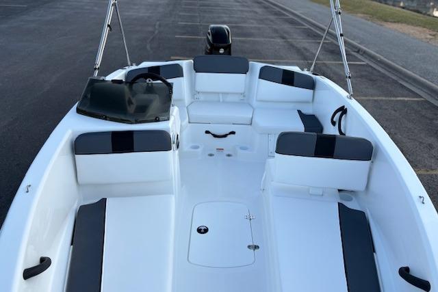 2026 Tahoe T16 boat interior with white and gray seating, parked on pavement.