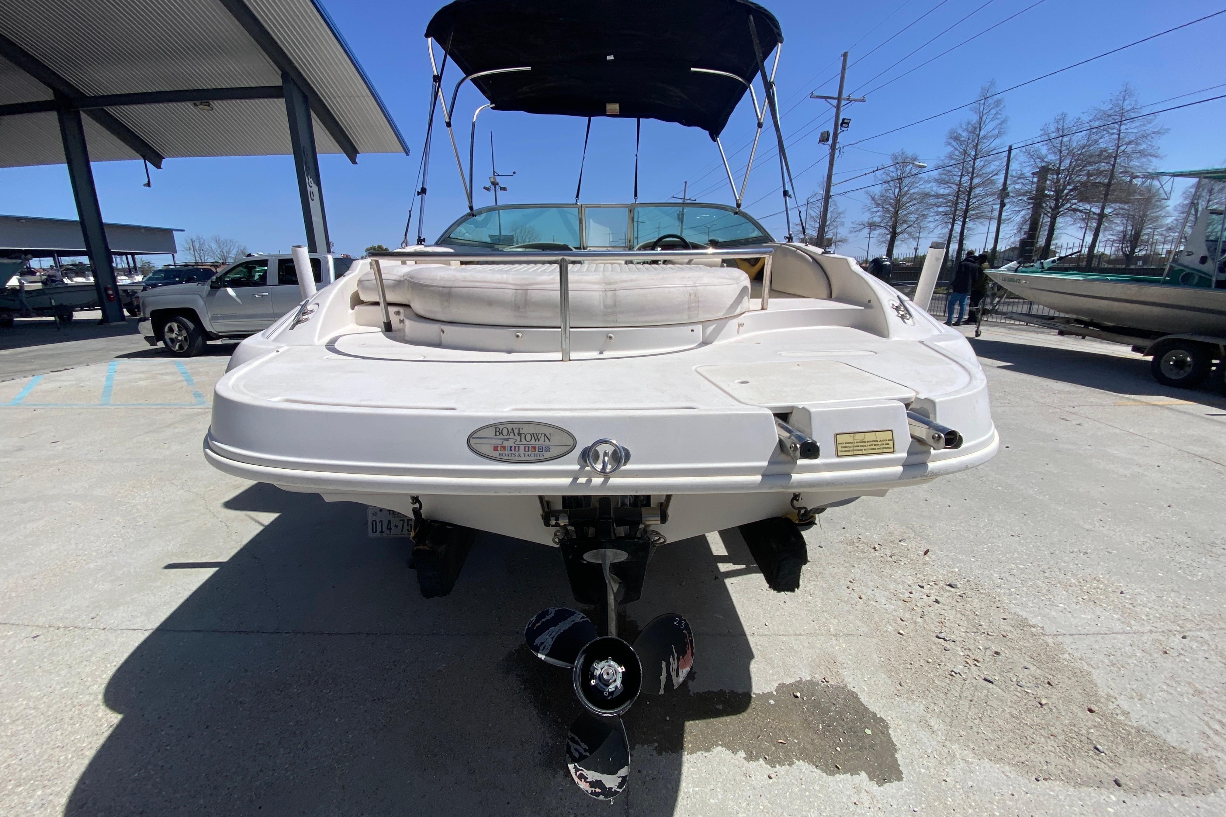2003 Monterey 208SI Montura boat, rear view, parked outdoors under clear sky.