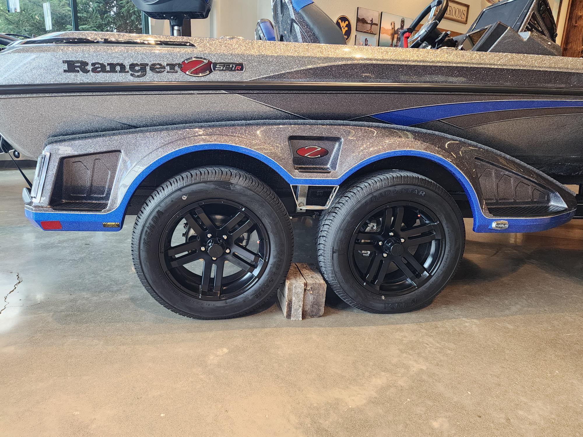2025 Ranger Z521R boat trailer with black wheels and blue accents on display.