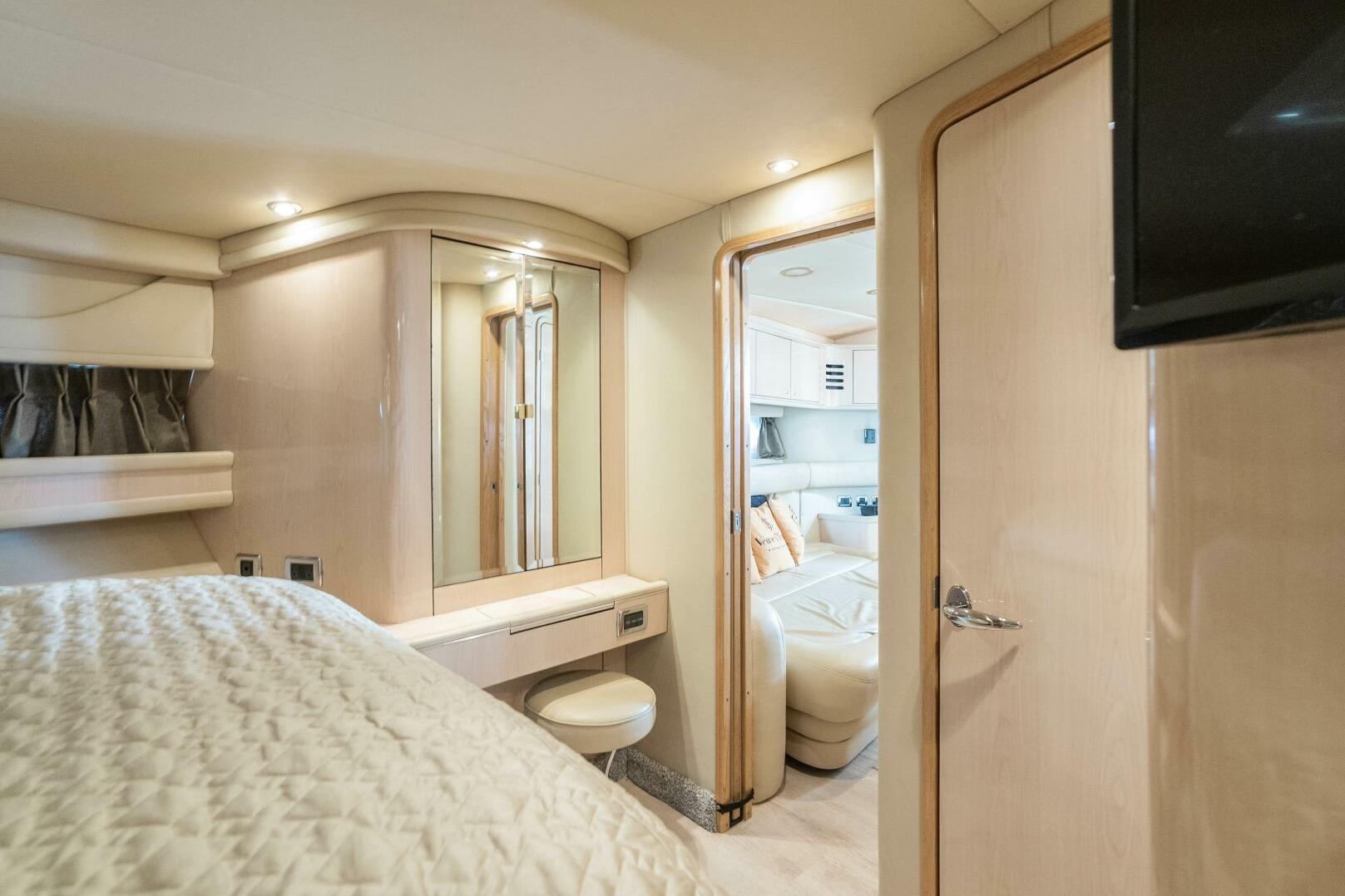Luxurious interior of 2003 Sea Ray Sundancer 460 yacht, featuring elegant bedroom and seating area.