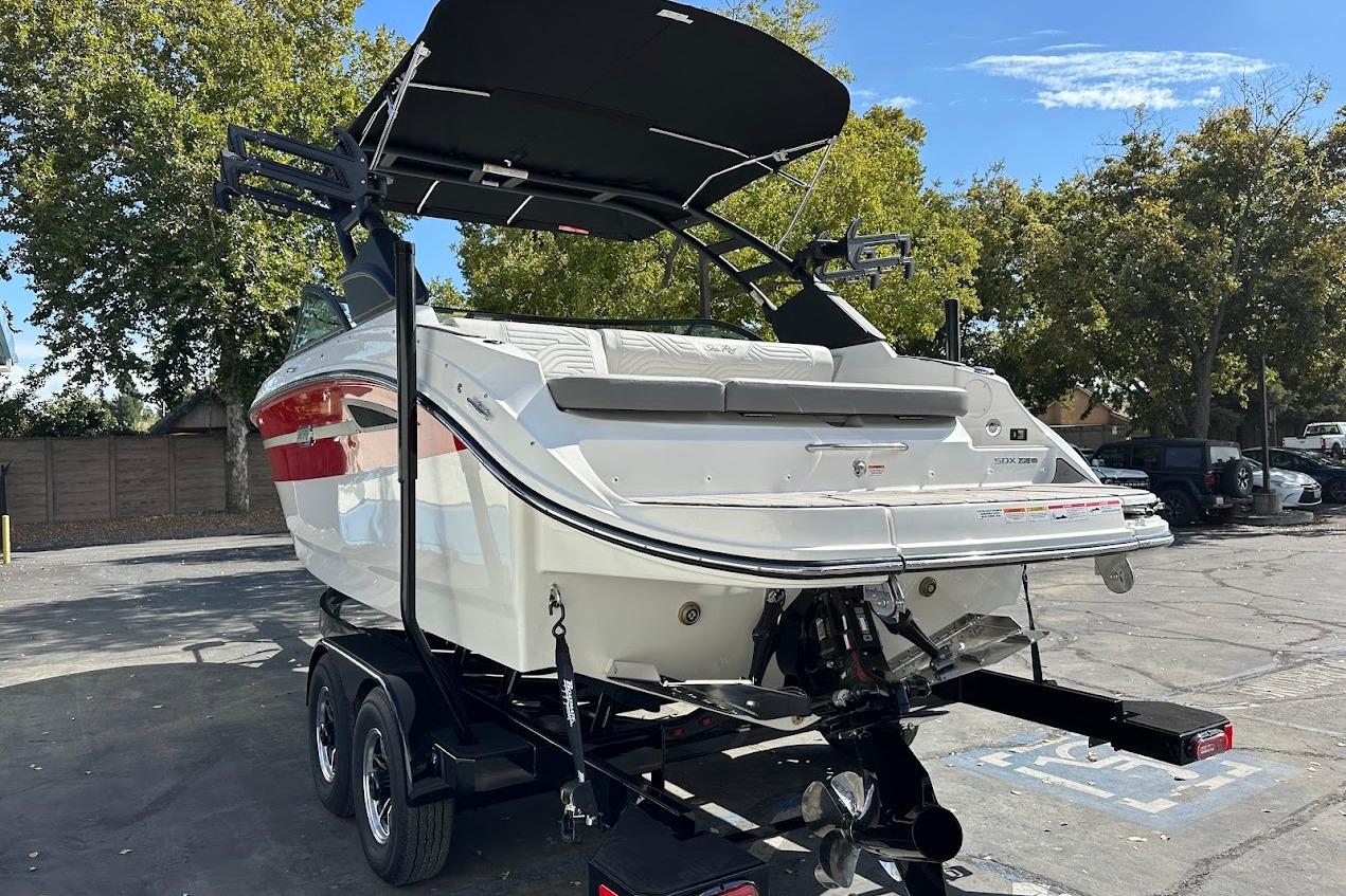 2026 Sea Ray SDX 230 Surf boat on trailer, parked outdoors under clear sky.