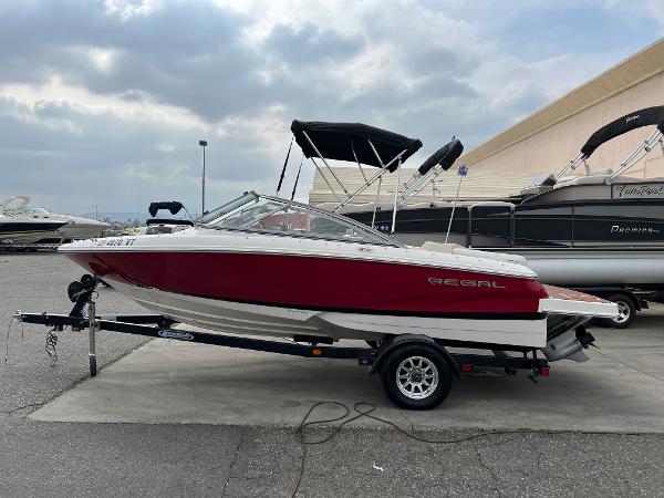 2013 Regal 1900 boat on trailer, red and white, parked at marina.