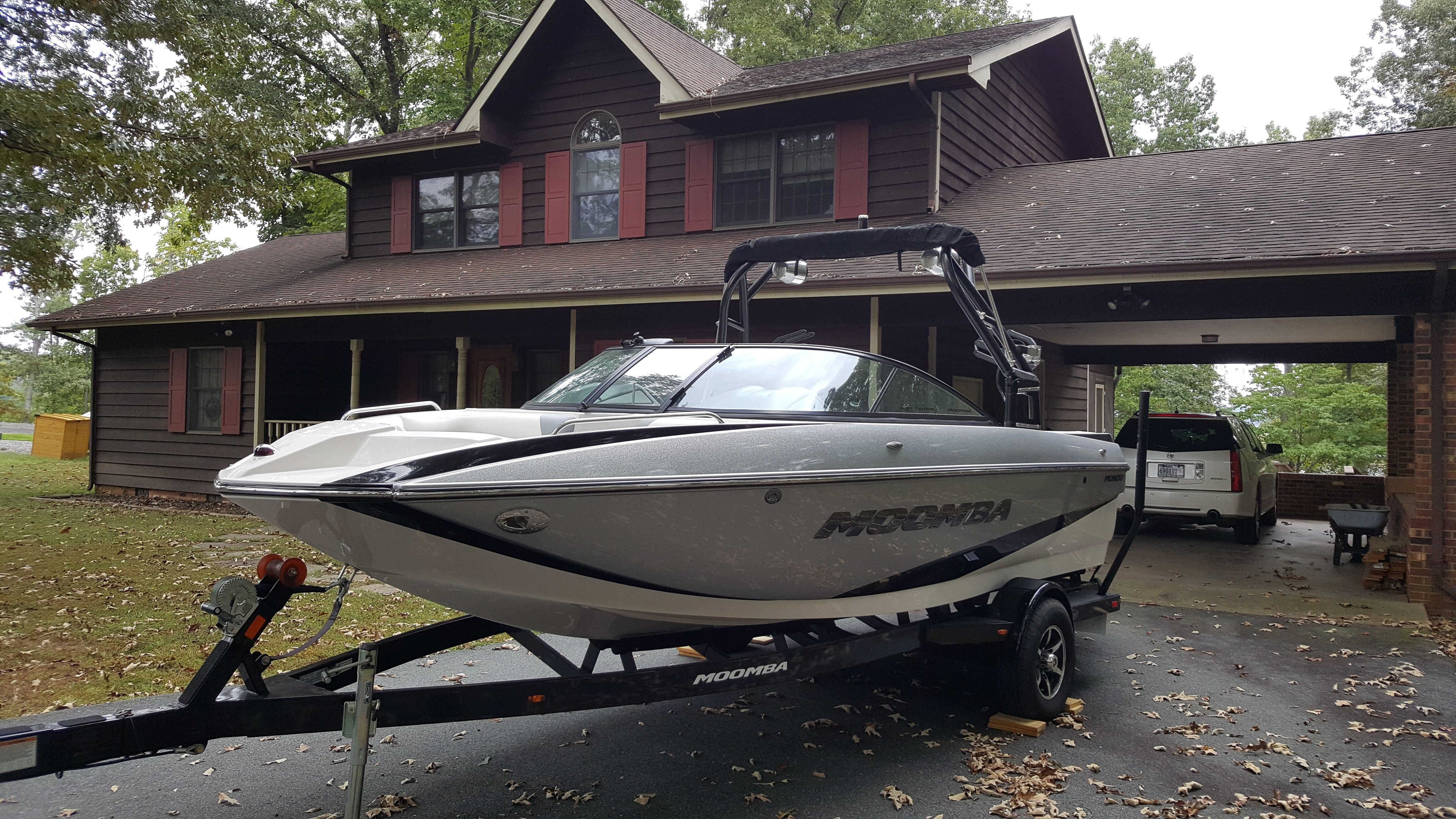 A 2016 Moomba Mondo boat on a trailer in front of a house.
