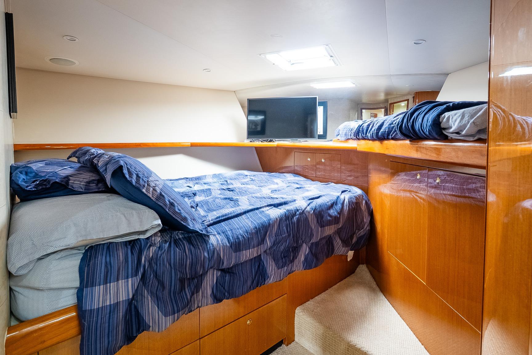 Luxurious cabin interior of 2002 Viking 61 Enclosed Bridge yacht with cozy bedding.