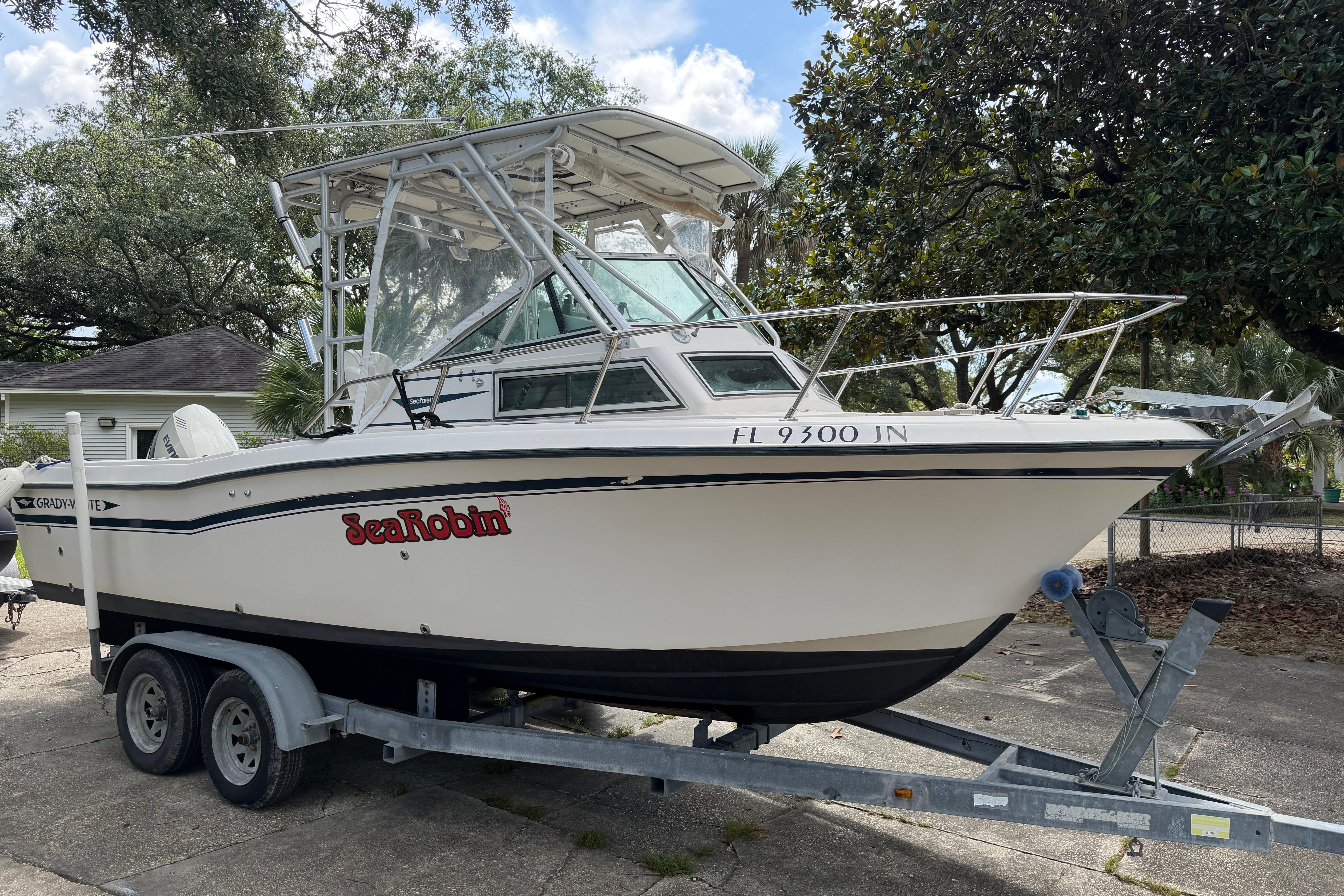 1987 Grady-White Seafarer 226 boat on trailer, labeled "Sea Robin," parked outdoors.