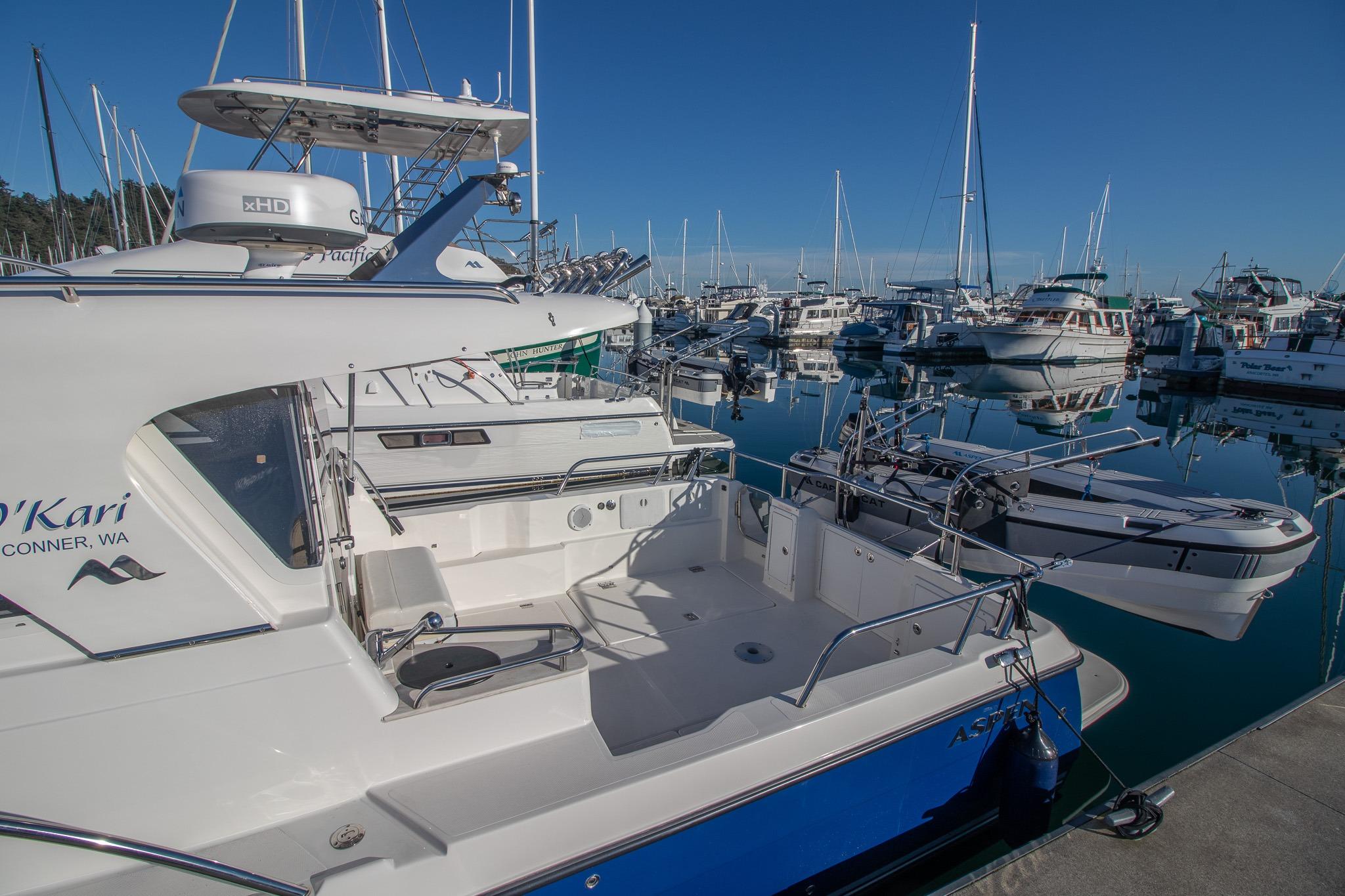 Aspen C100 2016 boat docked in a marina with clear blue skies.