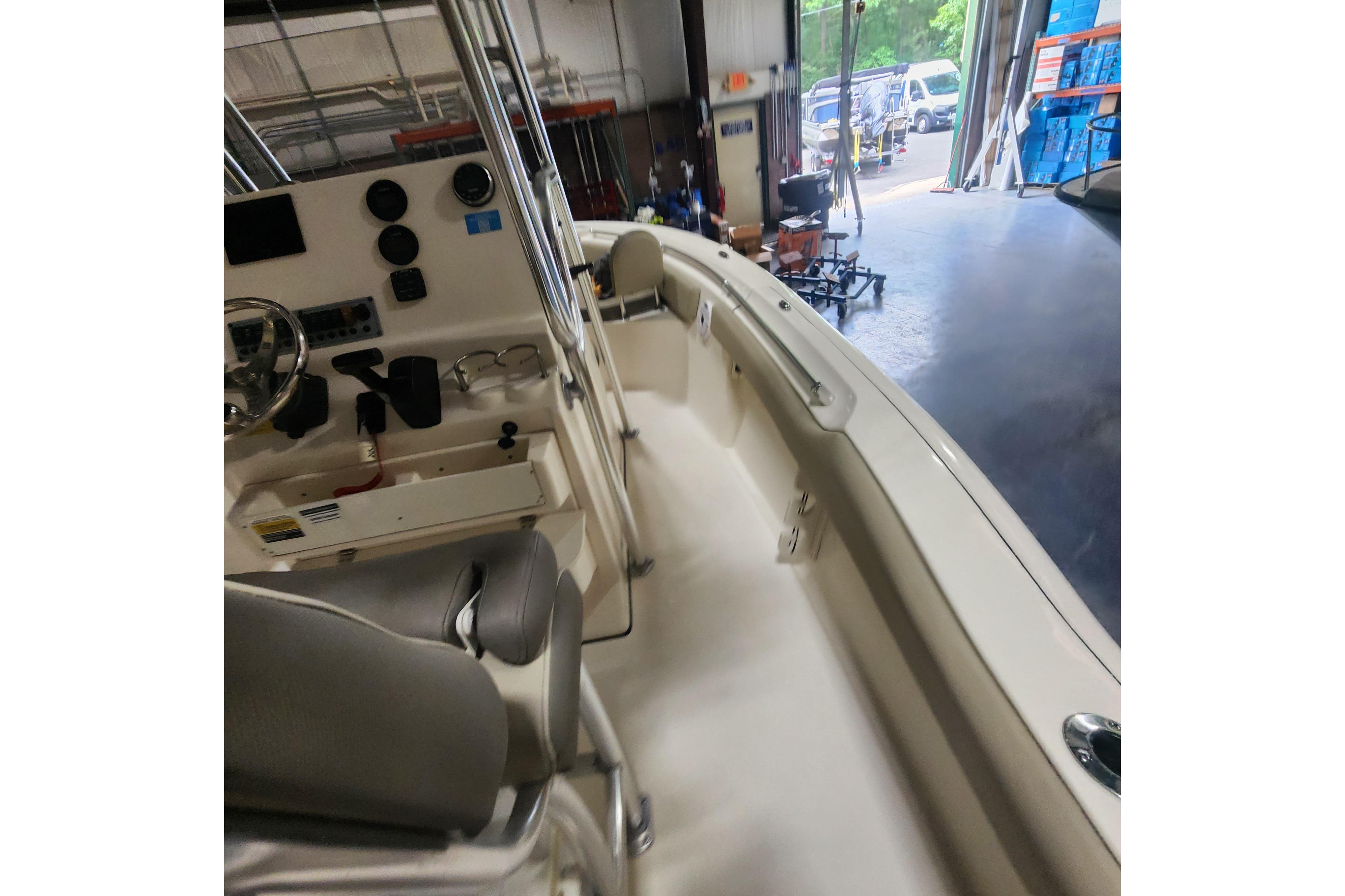 2023 Key West 219 FS boat interior with steering console in a warehouse setting.