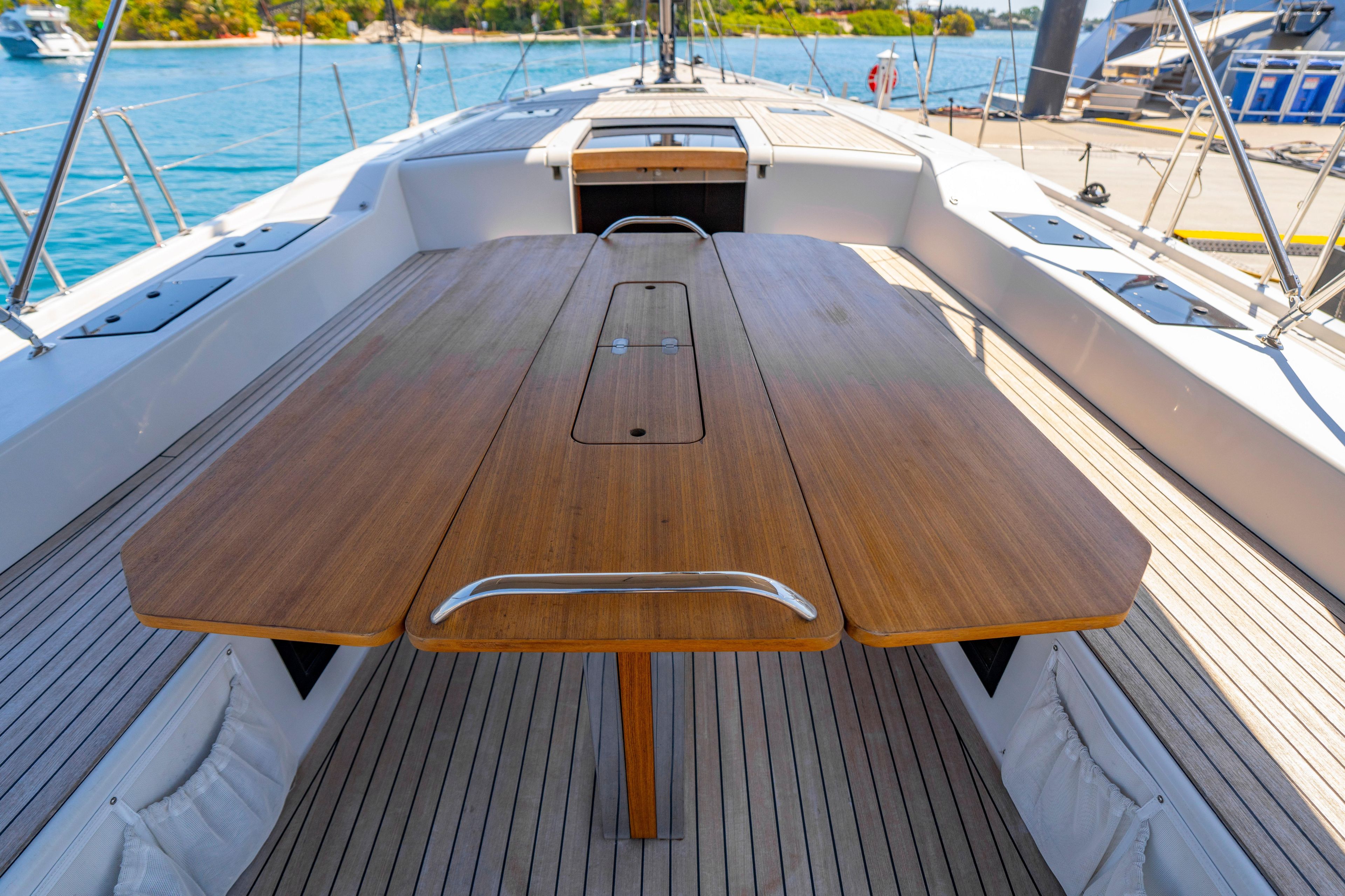 Deck view of 2016 Grand Soleil 58 yacht with wooden table and ocean backdrop.
