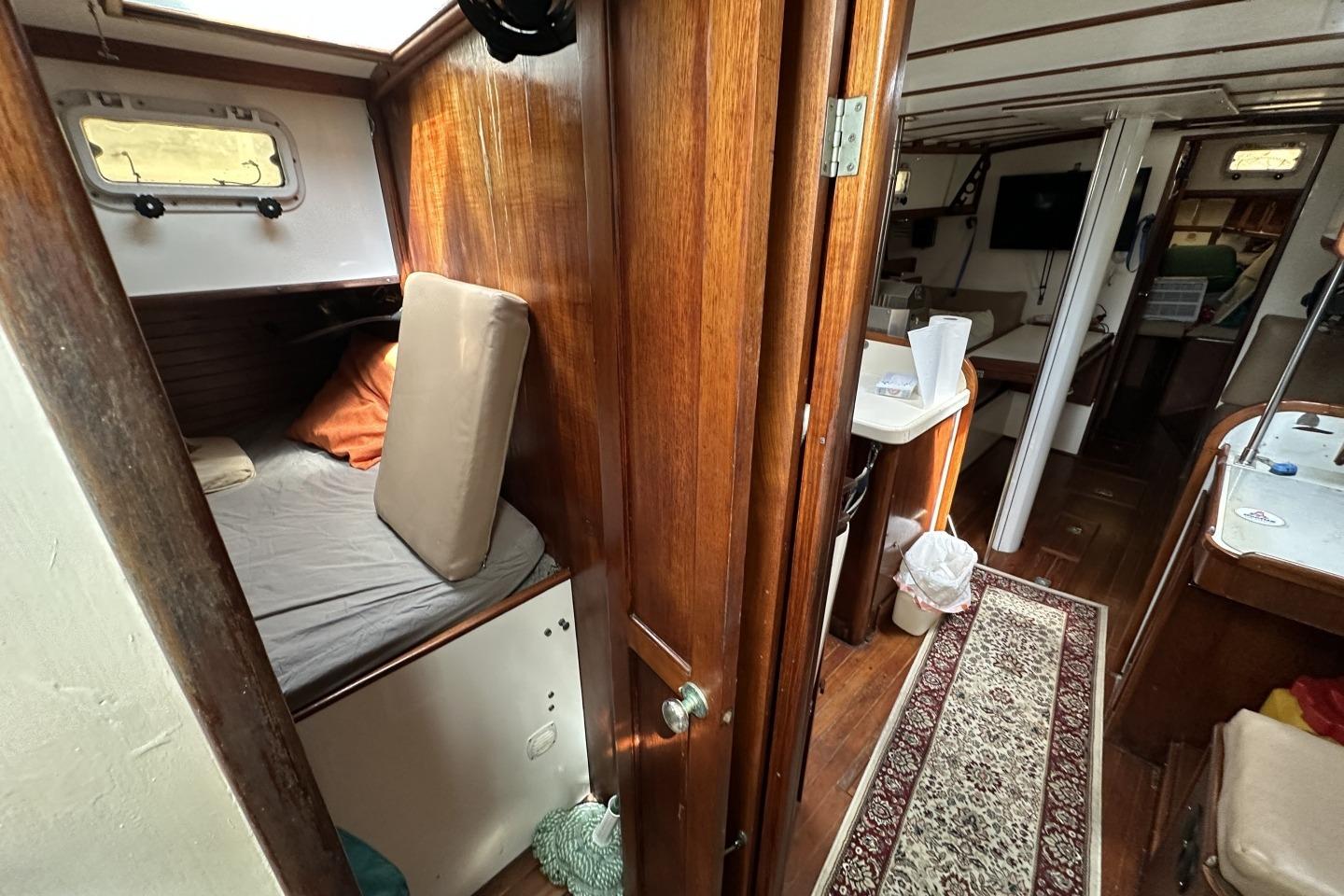 Interior of a 1976 Valiant 40 sailboat with wooden furnishings and cozy sleeping area.
