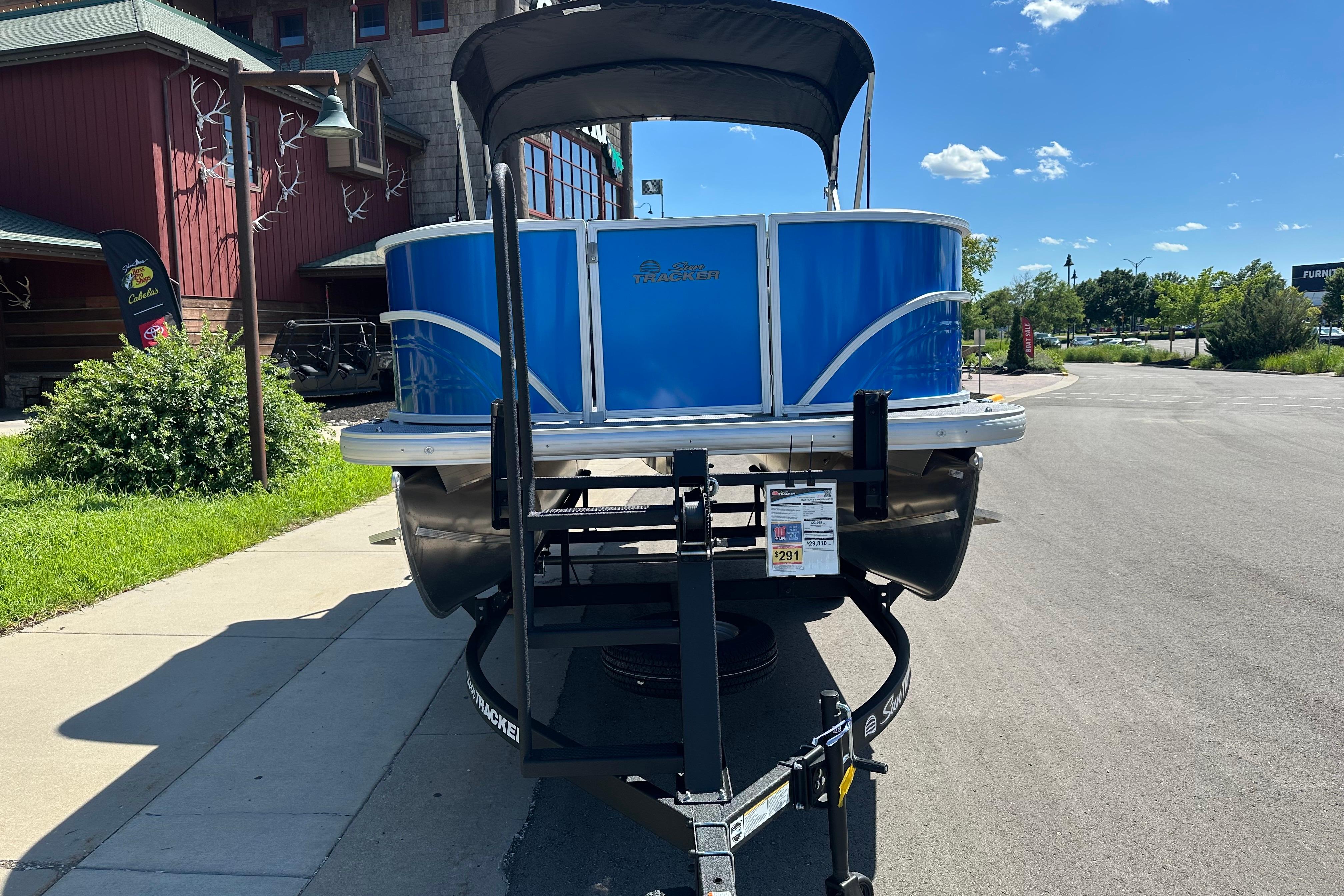 2026 Sun Tracker Party Barge 16 DLX pontoon boat on trailer, sunny day.