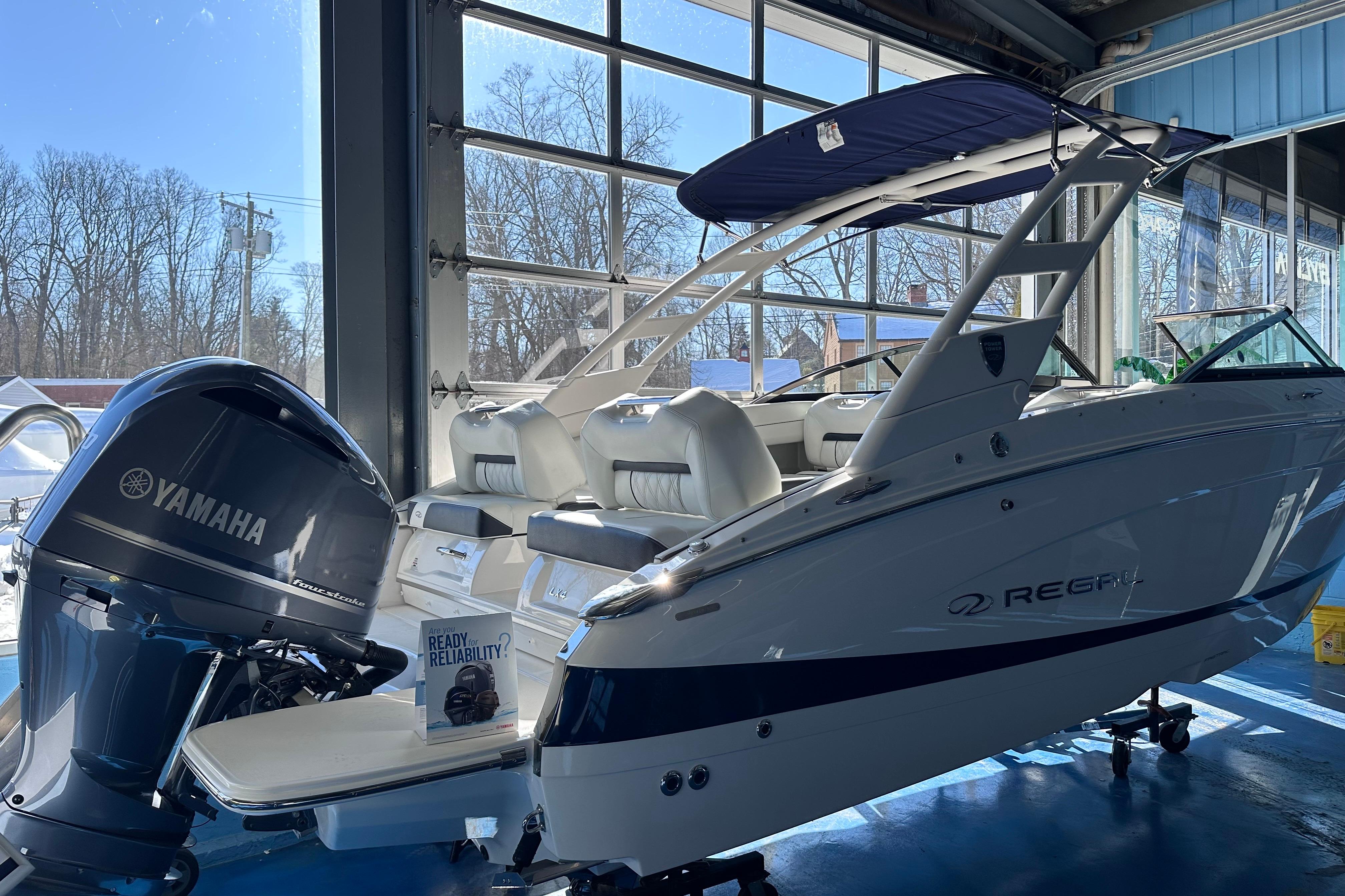 2026 Regal LX4 boat with Yamaha engine in showroom, featuring sleek design and modern amenities.