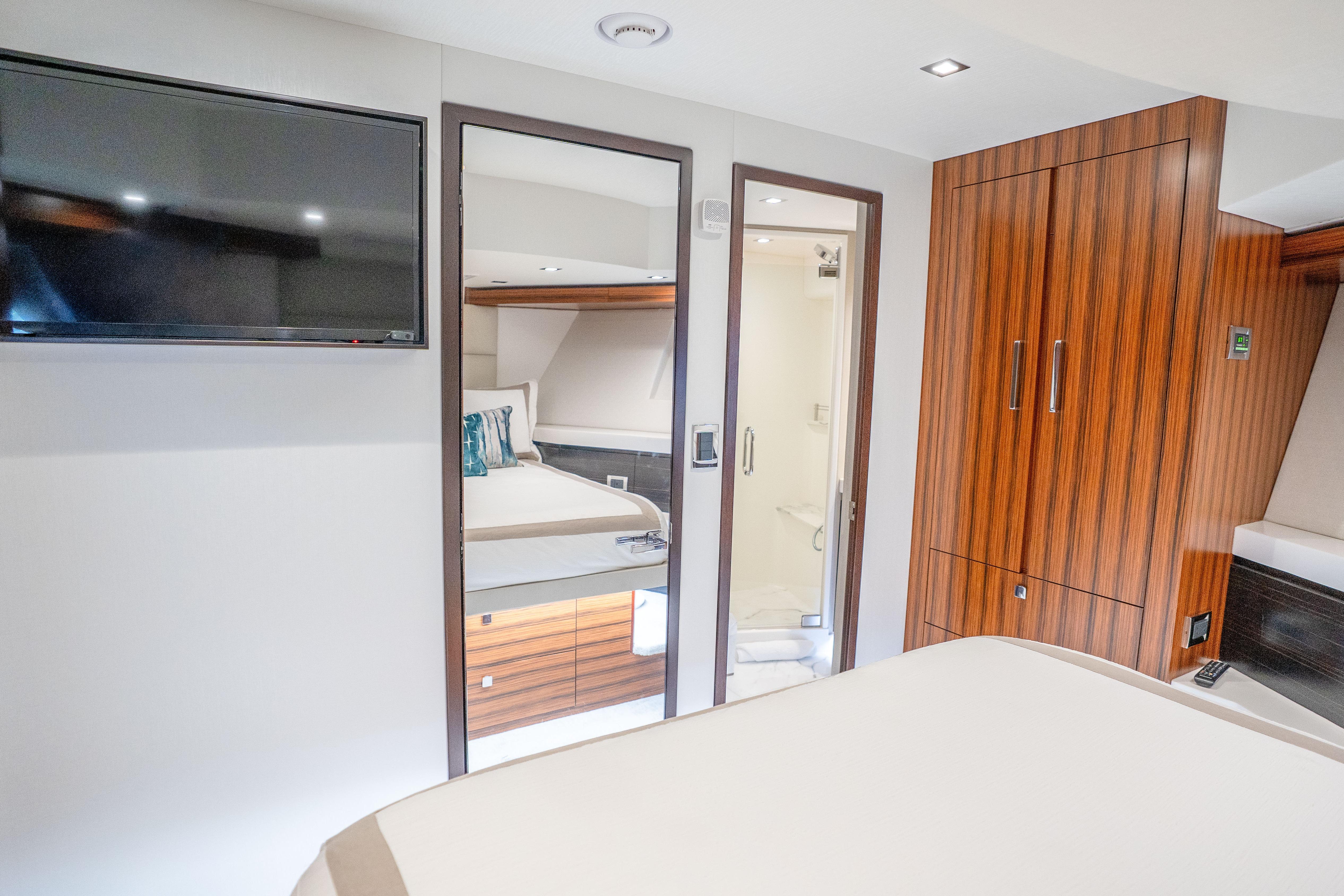 Luxurious interior of 2021 Hatteras M75 Panacera yacht with modern wood finishes and TV.