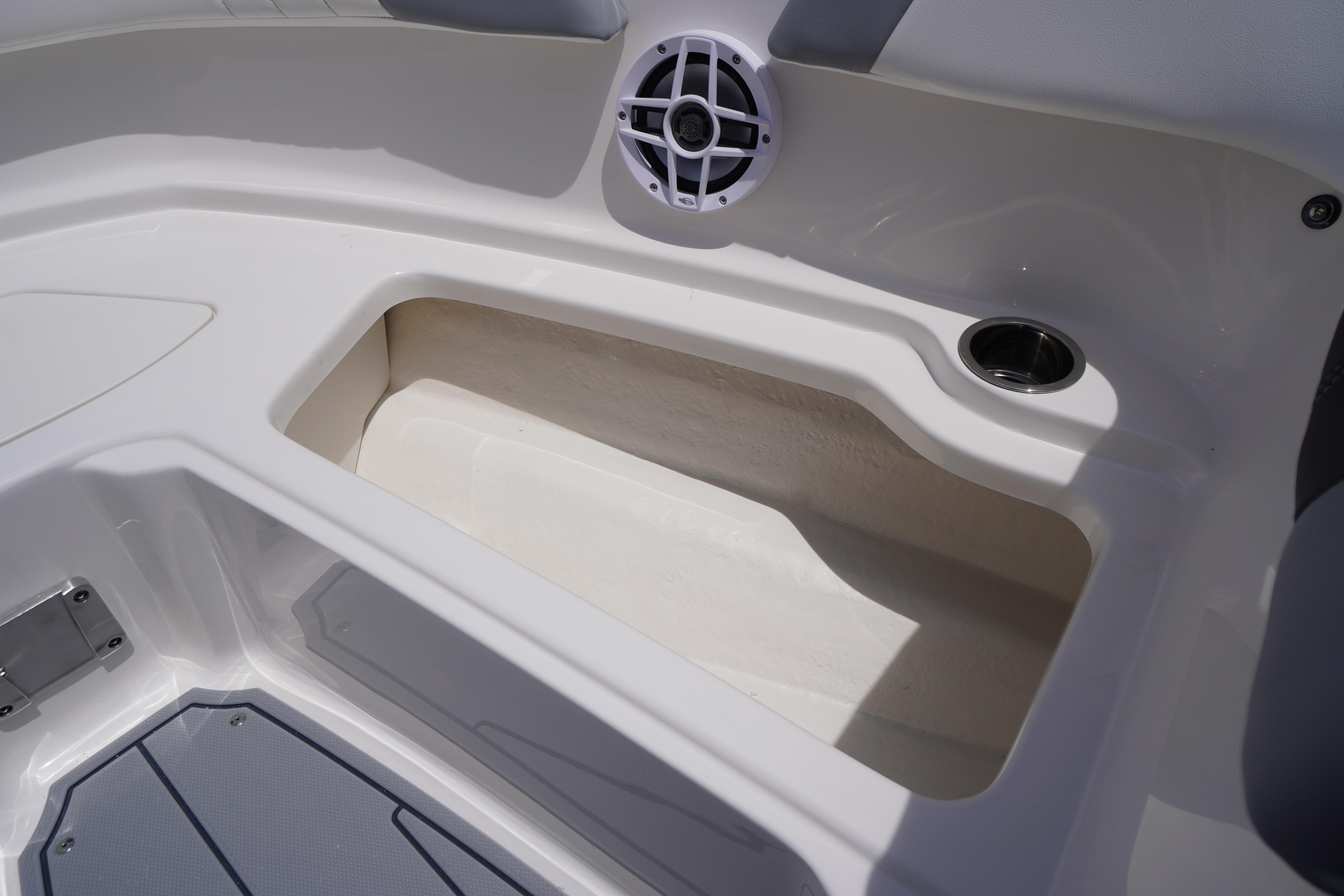 Interior storage compartment of 2026 Chaparral 23 SSi OB boat with speaker and cup holder.