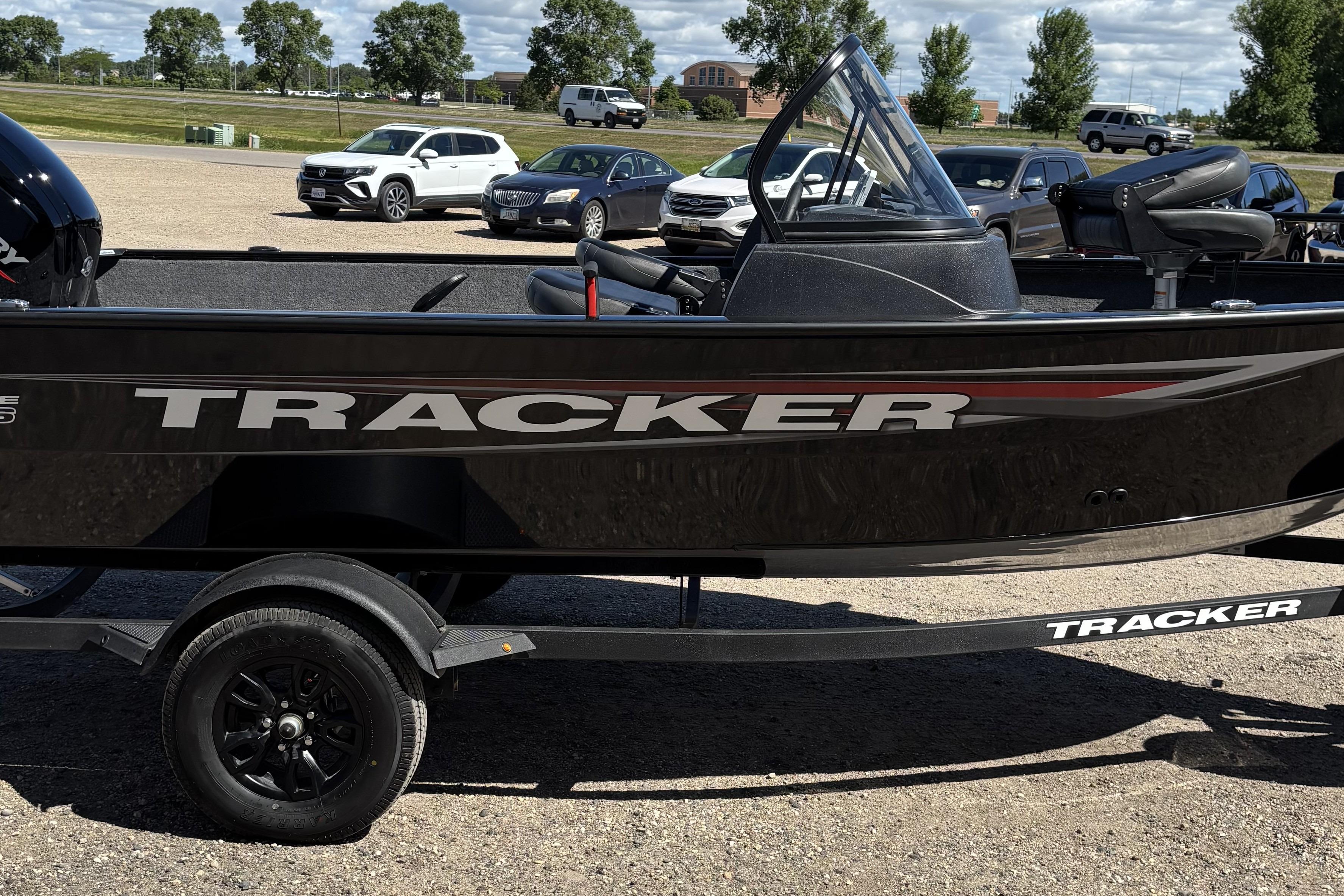 2026 Tracker Pro Guide V-16 WT boat on trailer in parking lot.