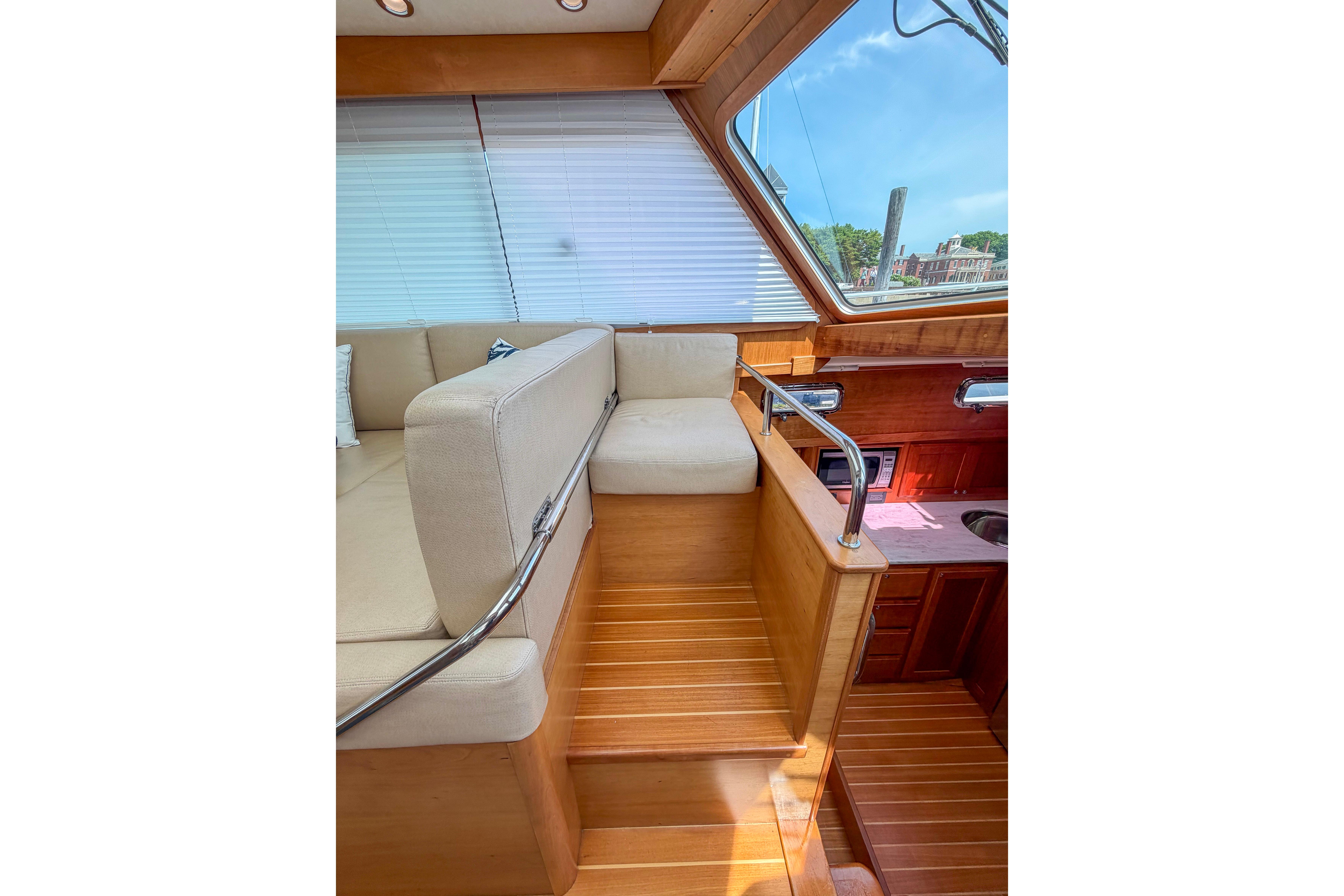Interior of 2013 Sabre 38 Salon Express yacht with wooden stairs and beige seating.