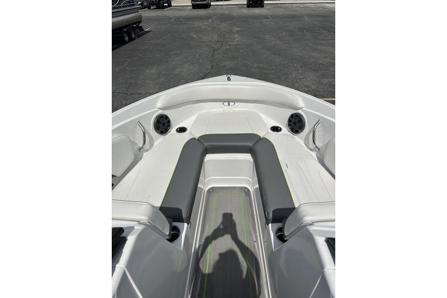 2024 Tahoe 210 S boat interior with seating and speakers, parked on asphalt.