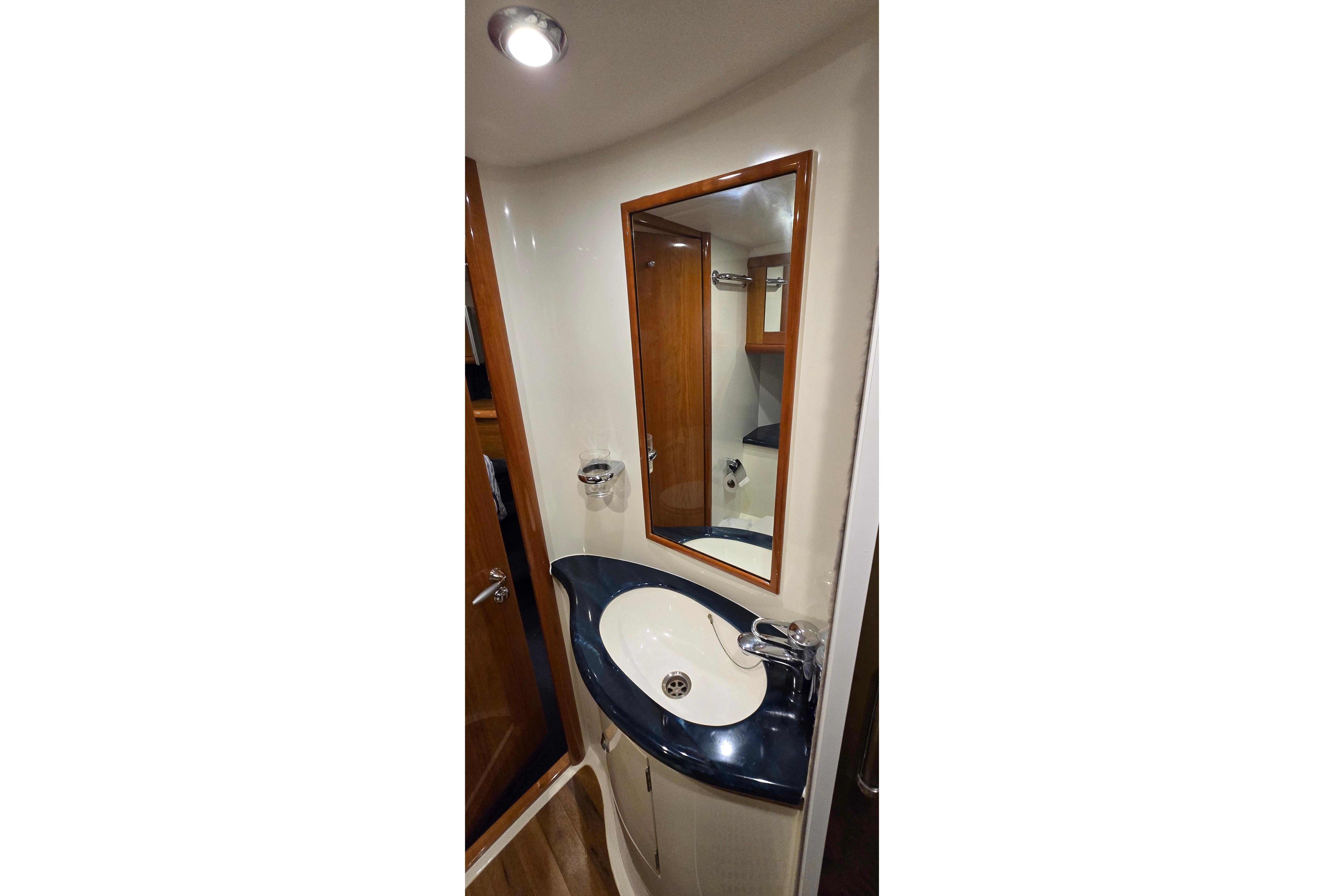Bathroom interior of 2004 Sunseeker Camargue 50 yacht with modern sink and mirror.