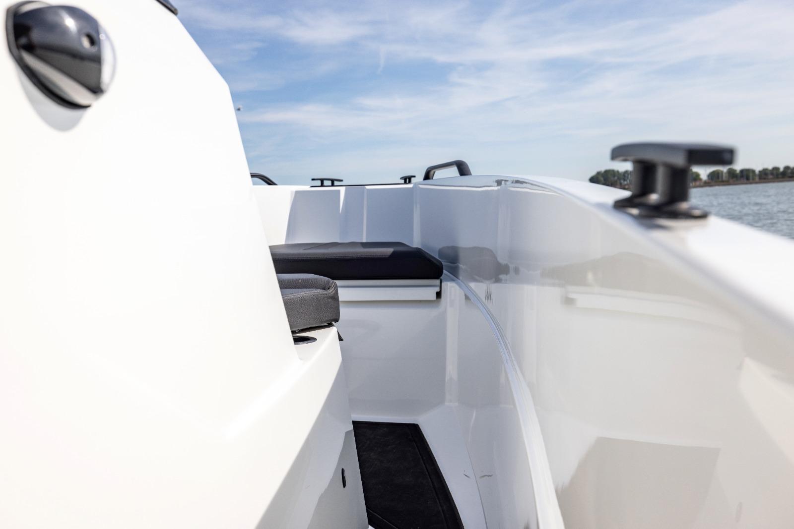 Iron 707 boat interior, sleek white design, black seating, 2022 model, clear sky background.
