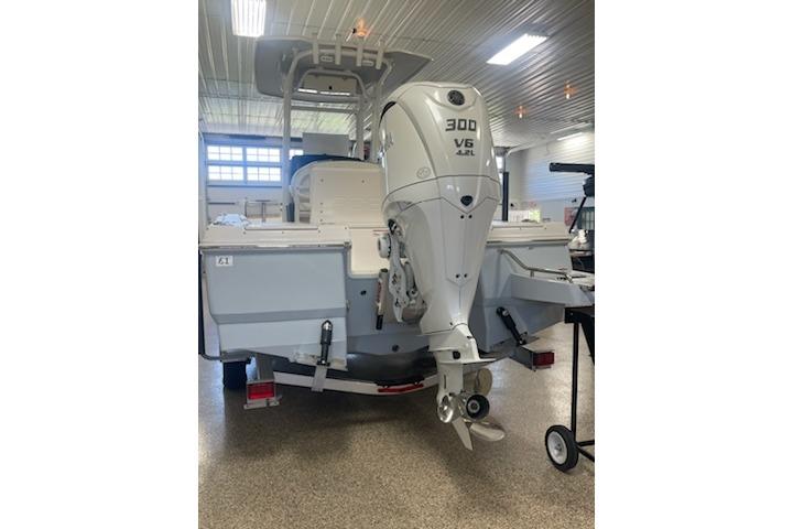 2024 Robalo 246 Cayman boat with 300 HP V6 engine in a showroom.