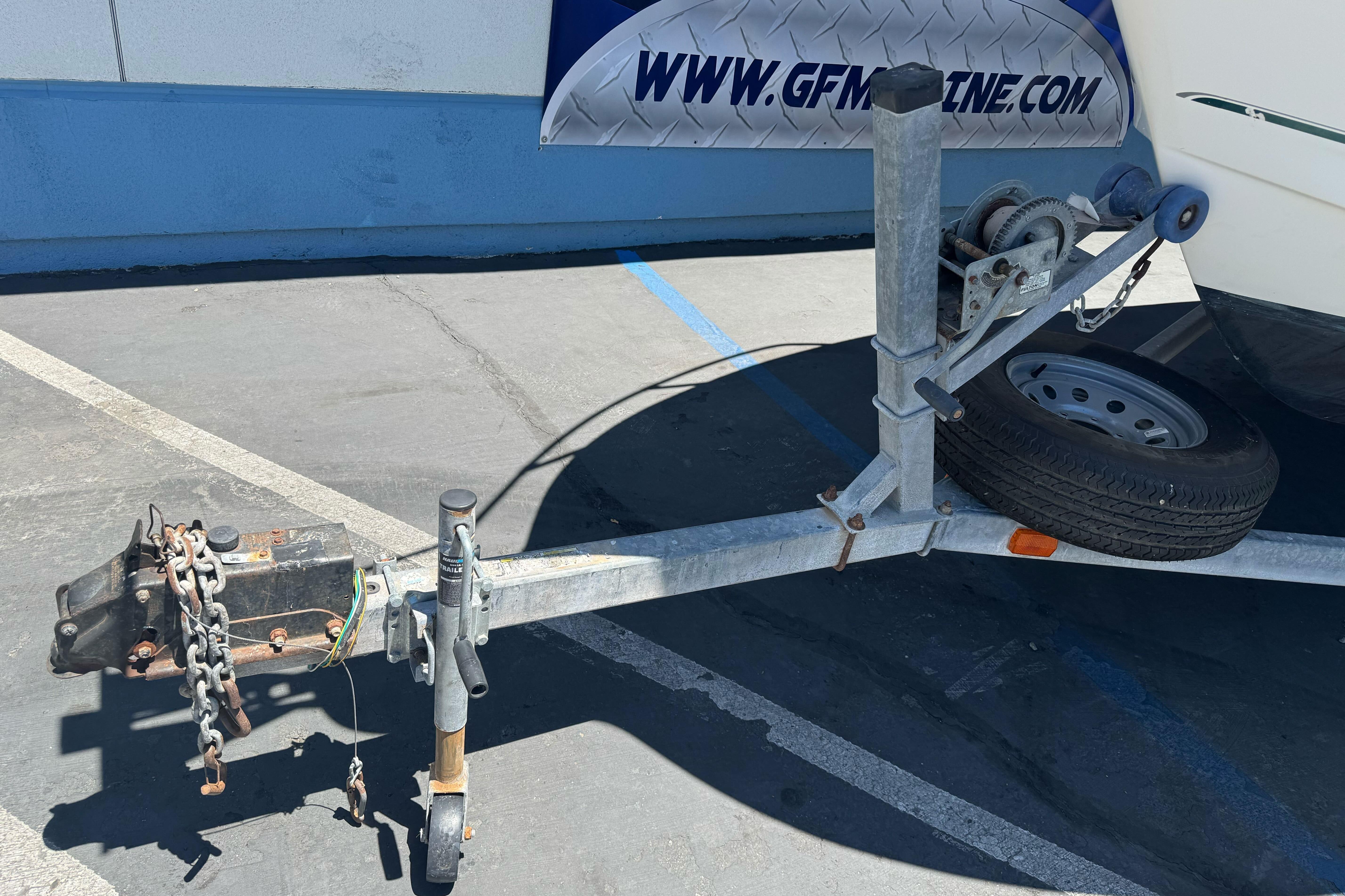 Trailer hitch and winch of a 2004 Trophy 2359 WA boat in a parking lot.