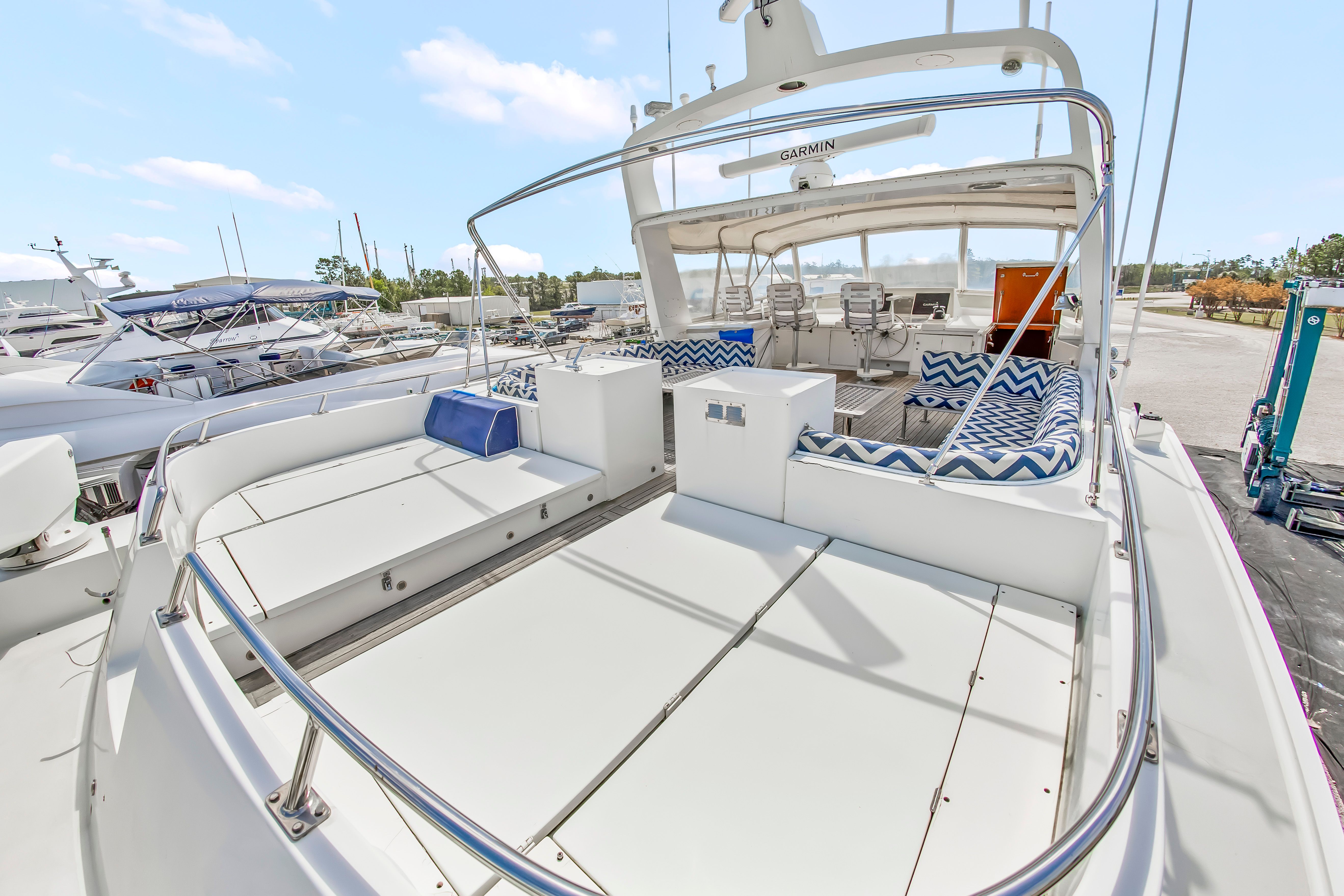 The image shows the deck of a 1987 Jongert 78 Motor Yacht with seating areas and blue cushions.