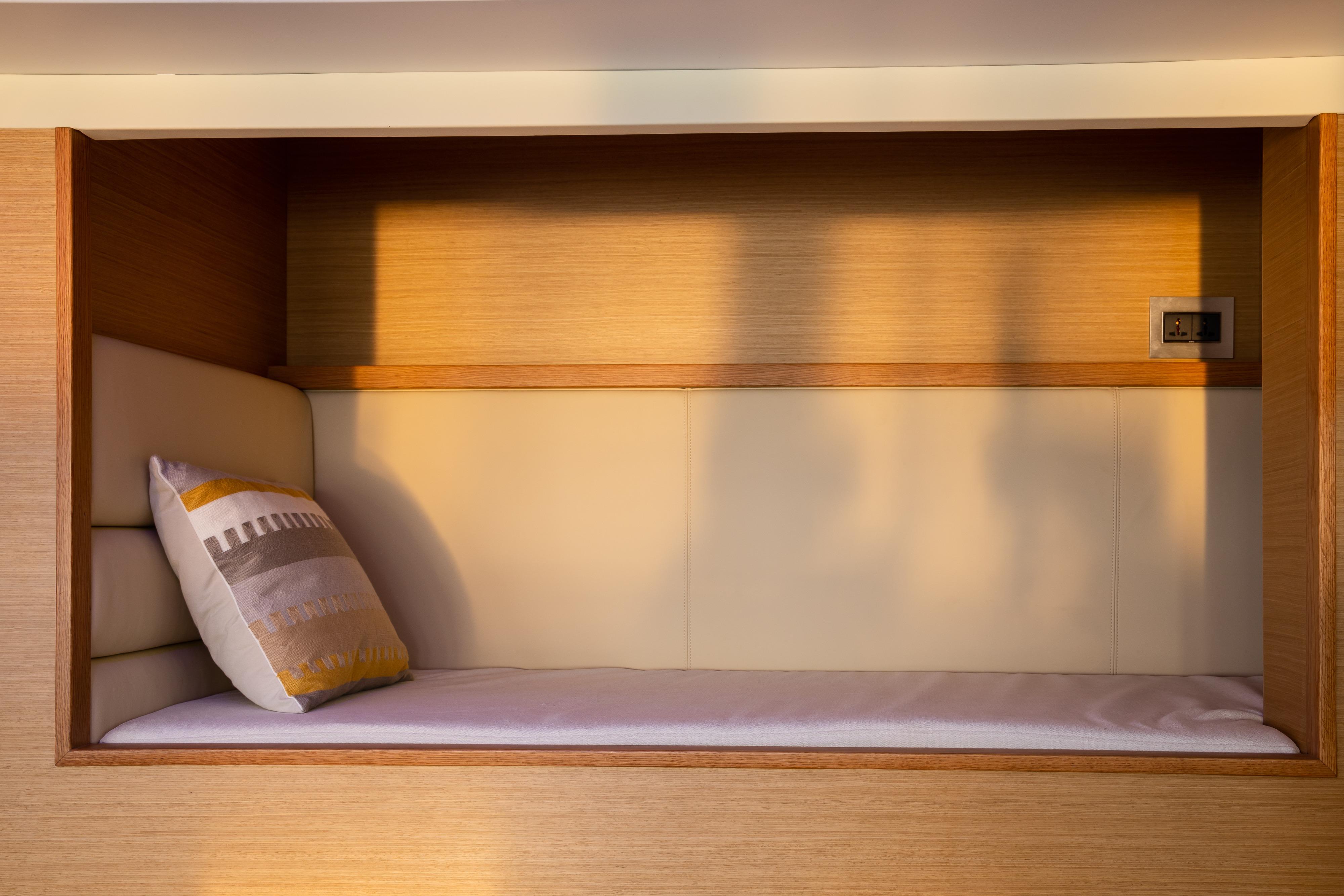 Cozy cabin interior of 2024 Selene 62' Explorer yacht with cushioned bed and pillow.