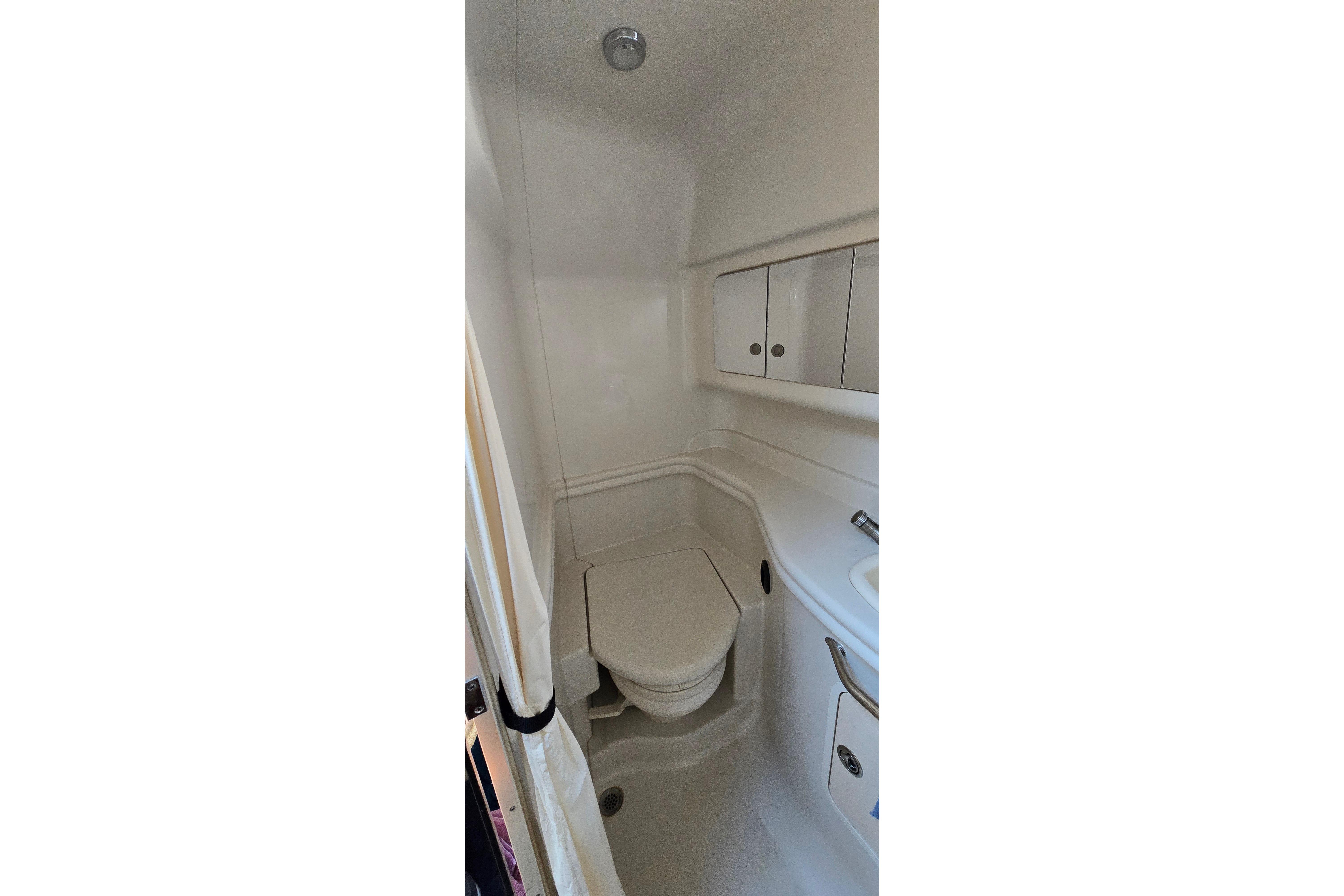 2007 Sea Ray 340 Sundancer bathroom interior with compact design and white fixtures.