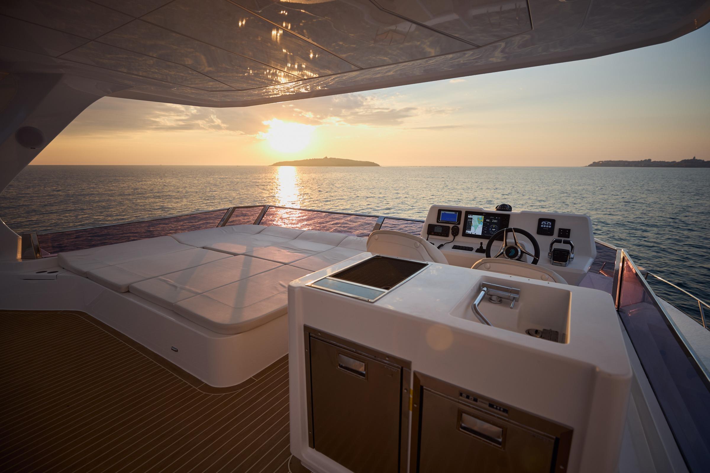 Luxurious 2025 Omaya 50 Power Catamaran at sunset, featuring spacious deck and modern helm.