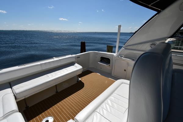 1997 Sea Ray 400 Sundancer yacht deck with ocean view, featuring white seating and wooden flooring.