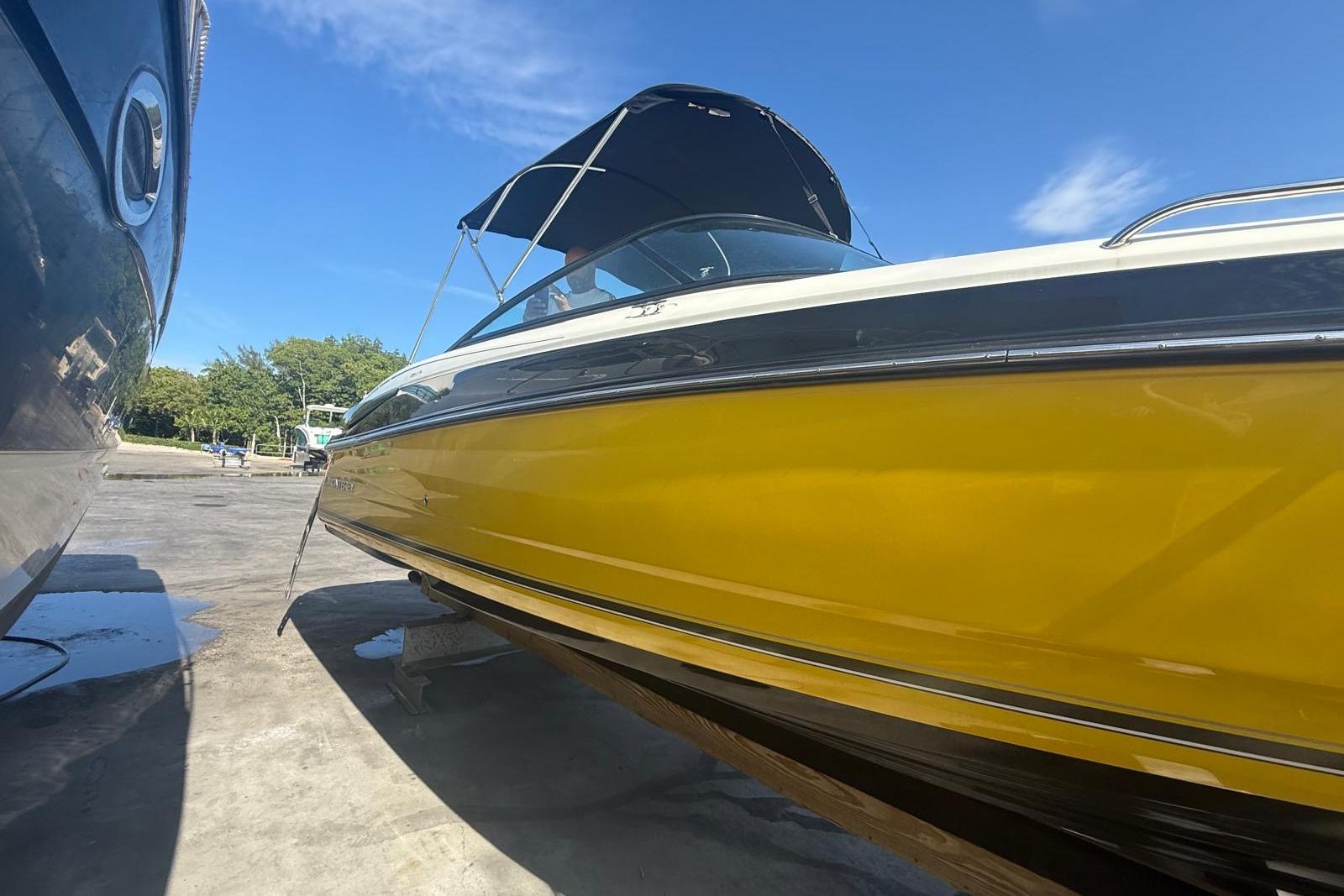 2015 Monterey 264FS boat with yellow hull and canopy, docked under clear blue sky.