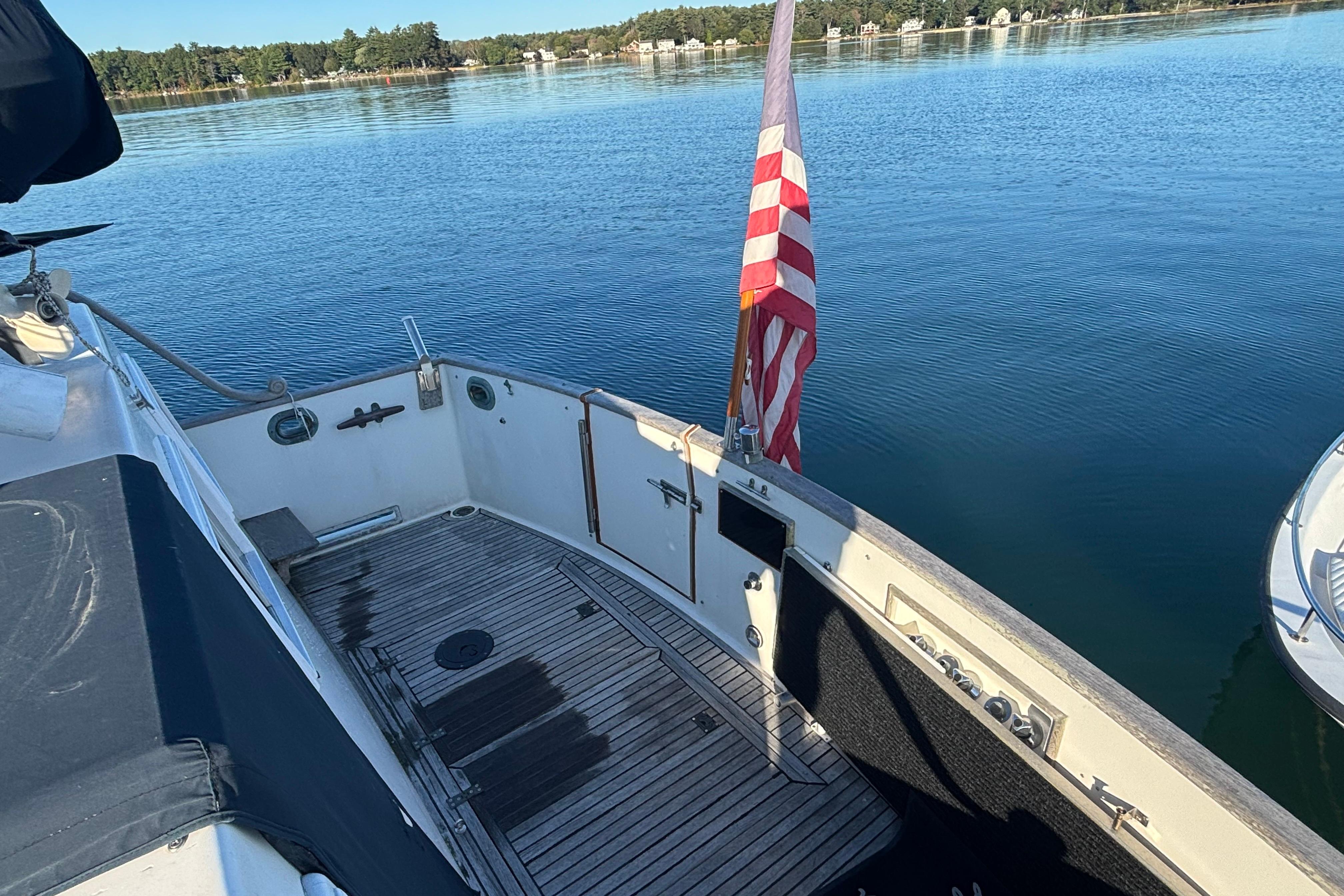 1989 Grand Banks 46 Classic yacht deck with American flag on calm water.