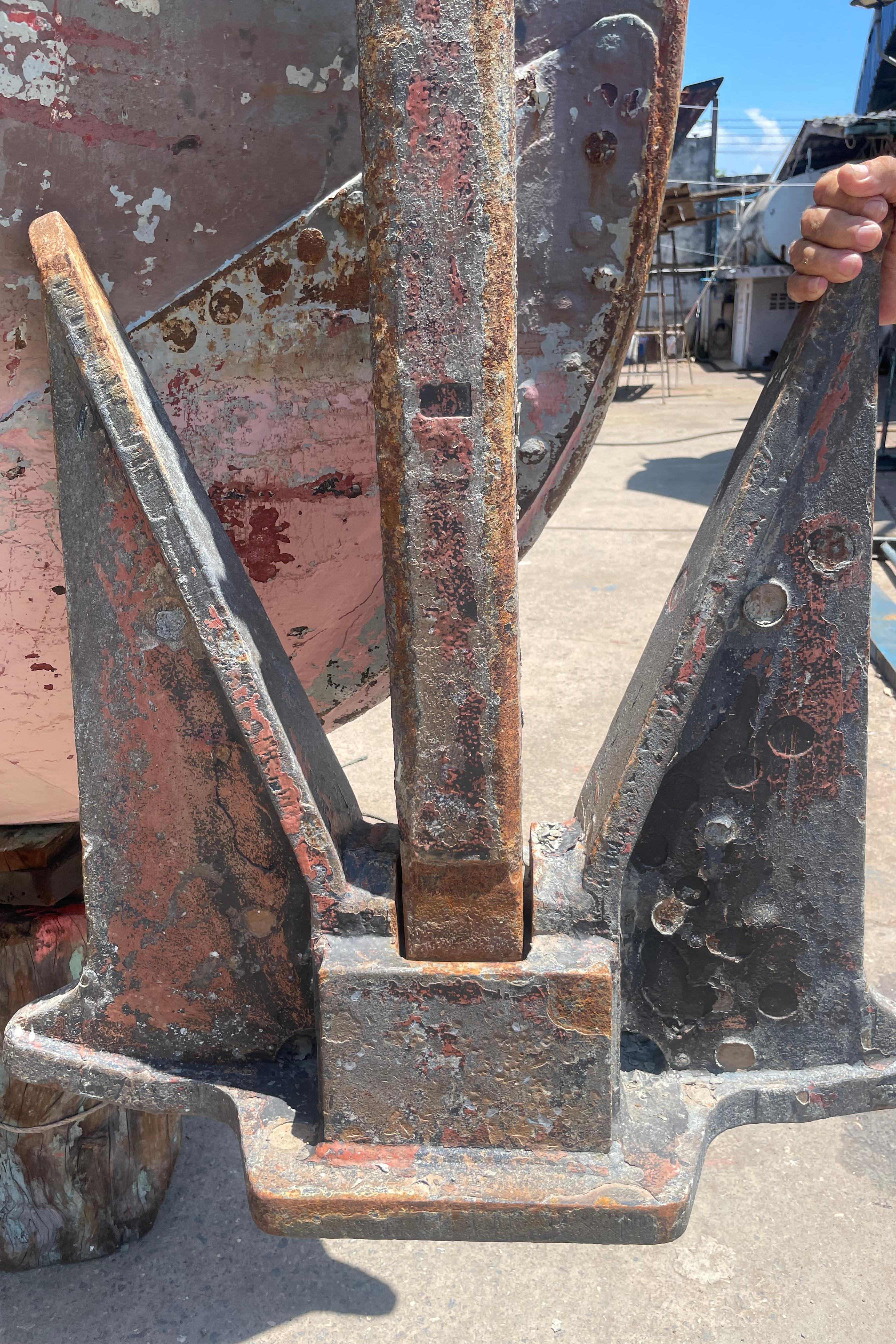 Rustic 1930 Custom Gronigen ship anchor with weathered patina, displayed outdoors.