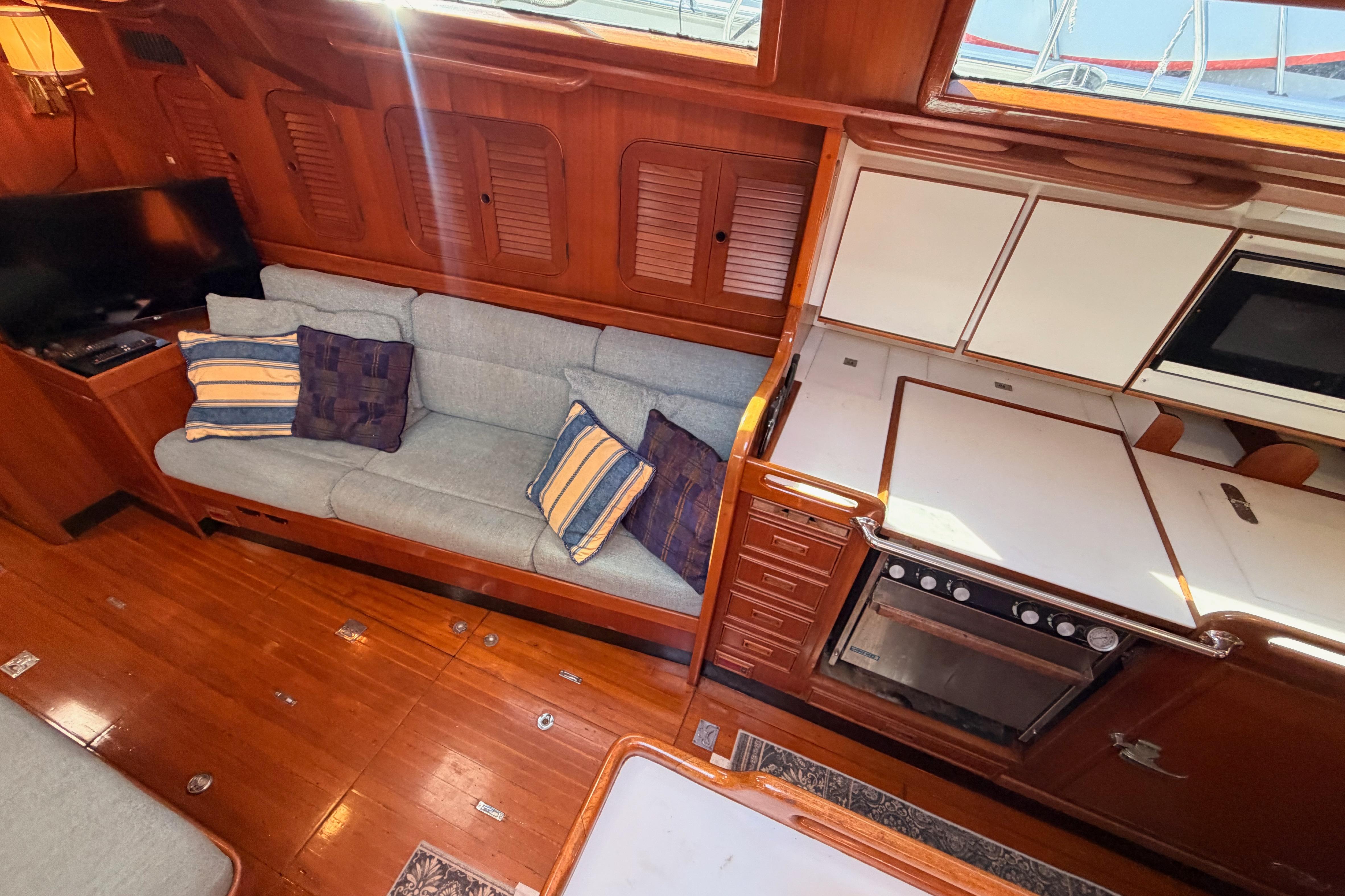 Interior of 1991 Hylas 51 yacht with cozy seating and modern kitchen amenities.