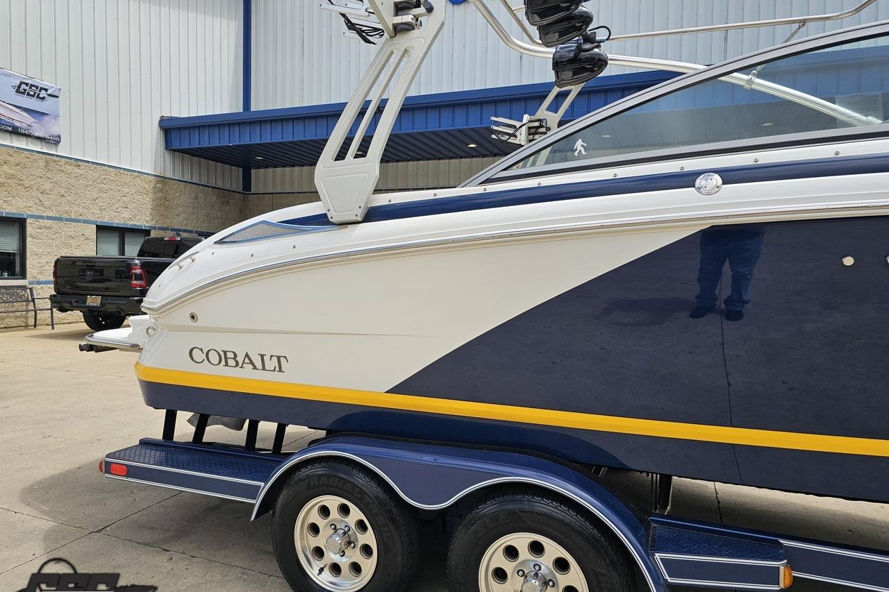 2010 Cobalt 232 WSS boat on trailer, parked outside a building.