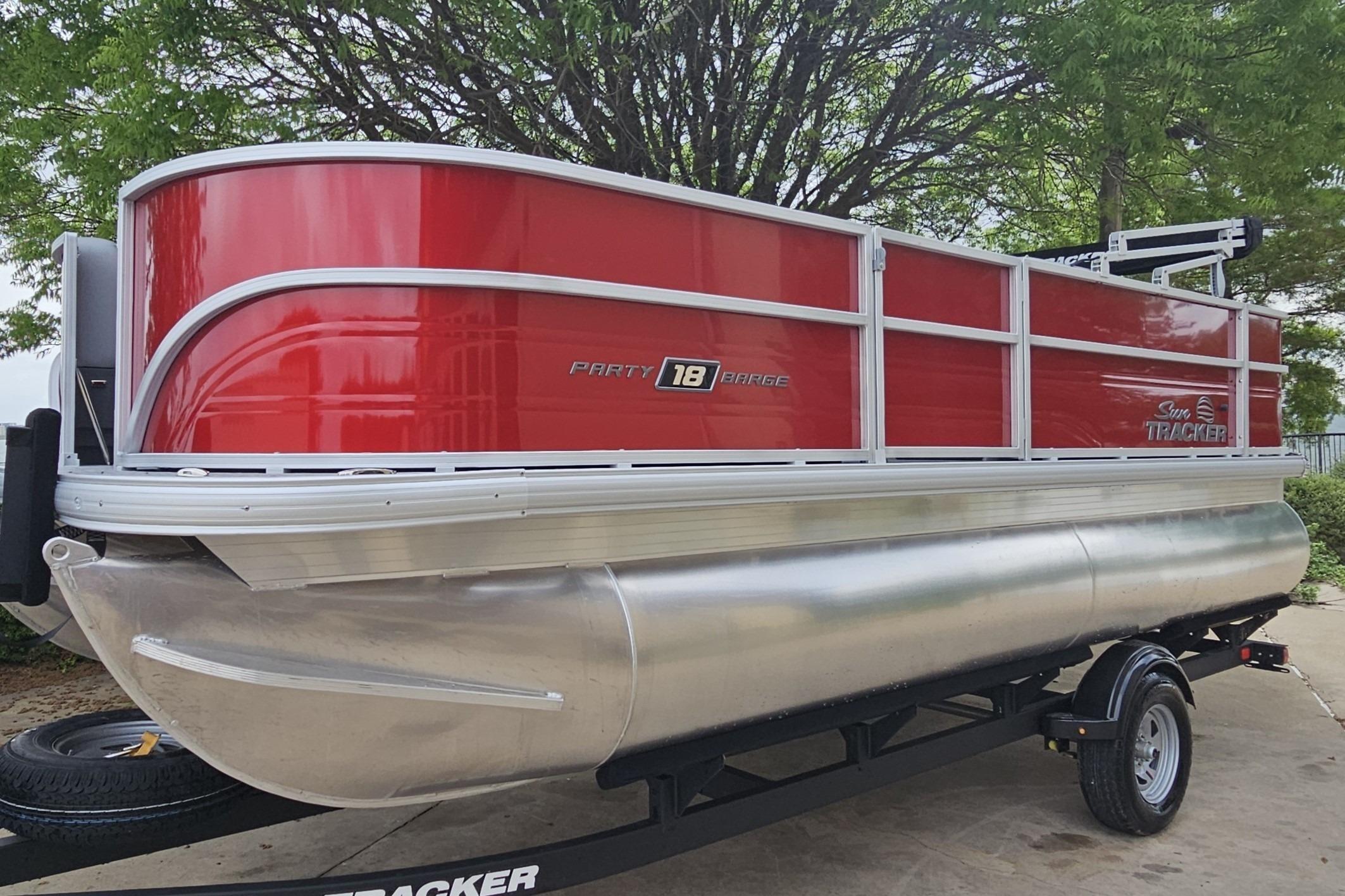 2026 Sun Tracker Party Barge 18 DLX pontoon boat with red exterior on trailer.