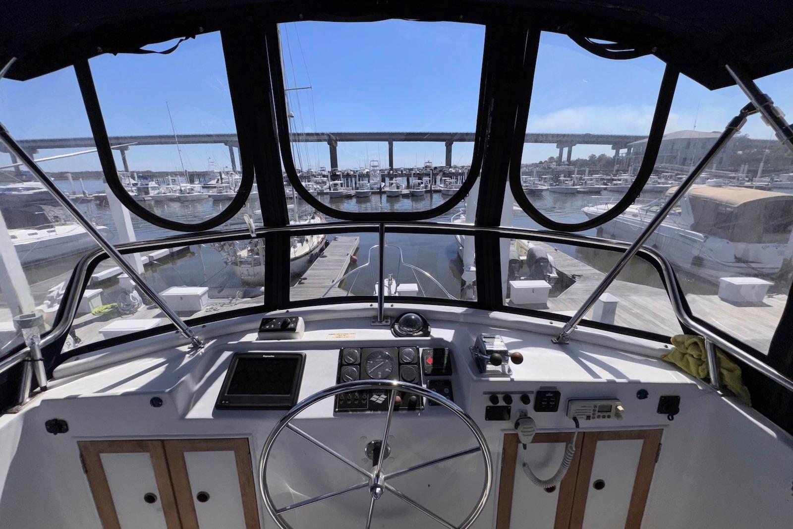 Interior view of 1995 Island Gypsy Eurosedan 32 yacht cockpit with marina backdrop.