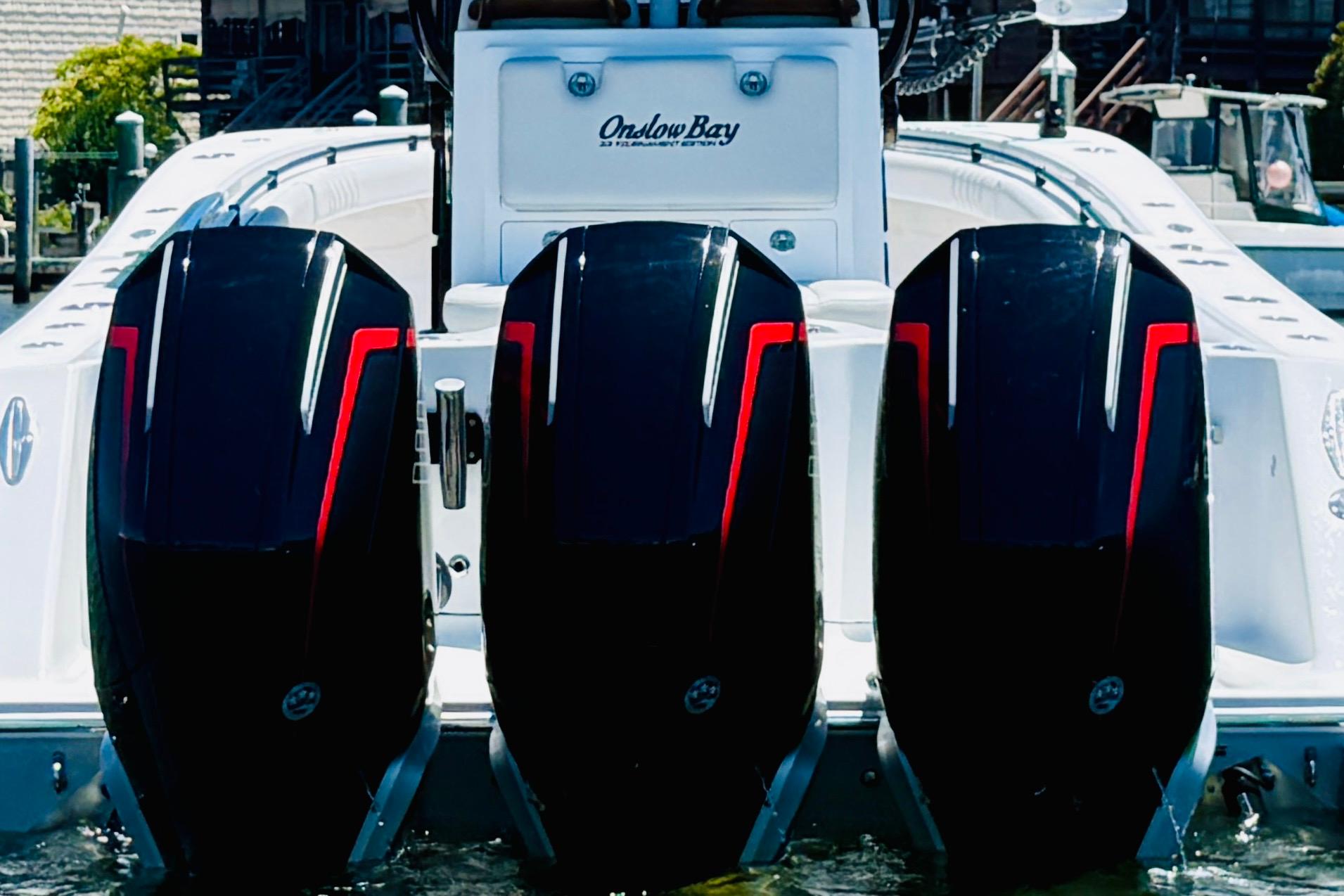 2026 Onslow Bay boat with three powerful outboard motors, docked in a marina.