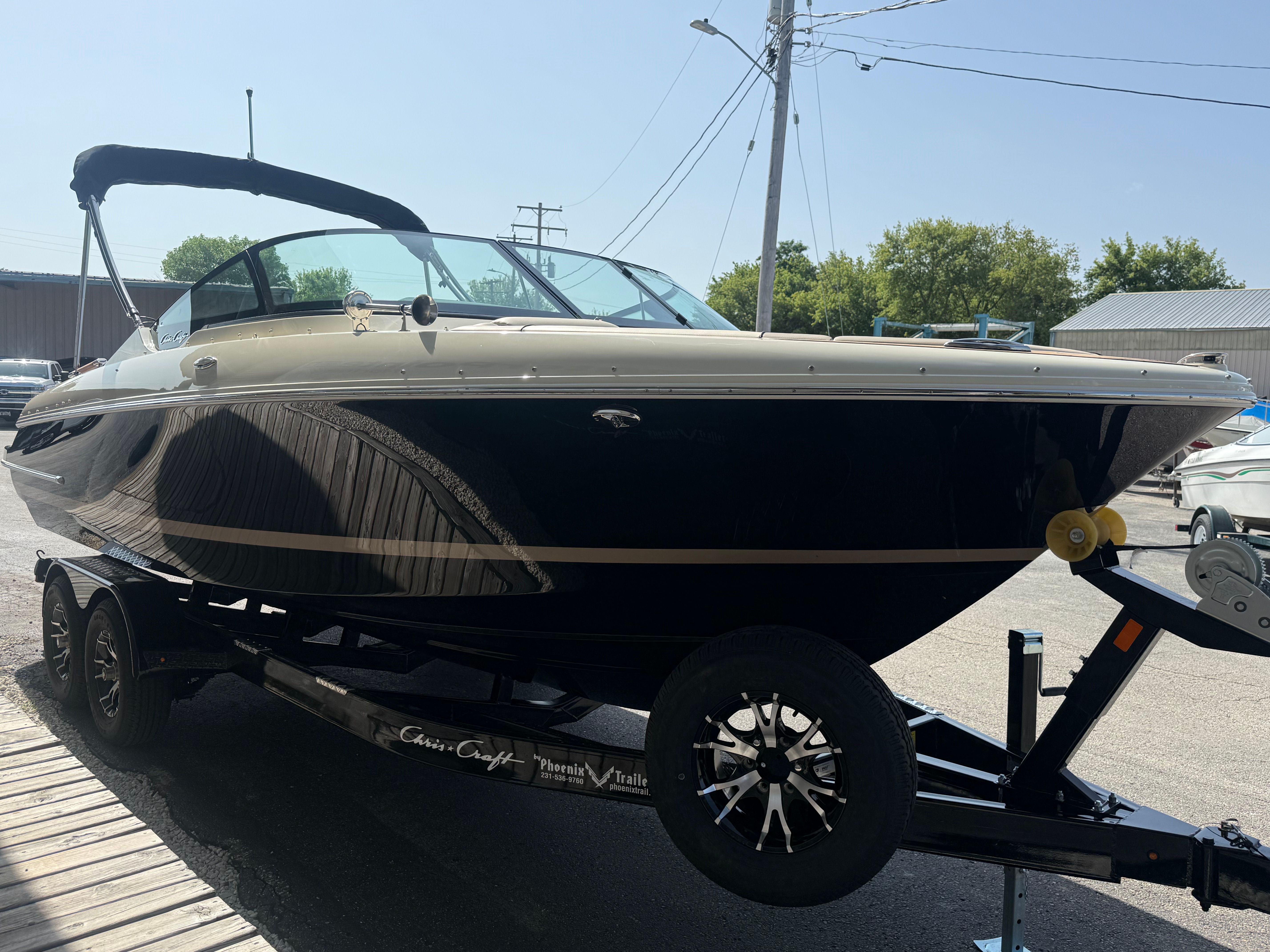 A 2027 Chris-Craft Sportster 25 on a trailer. It features a sleek black hull design.