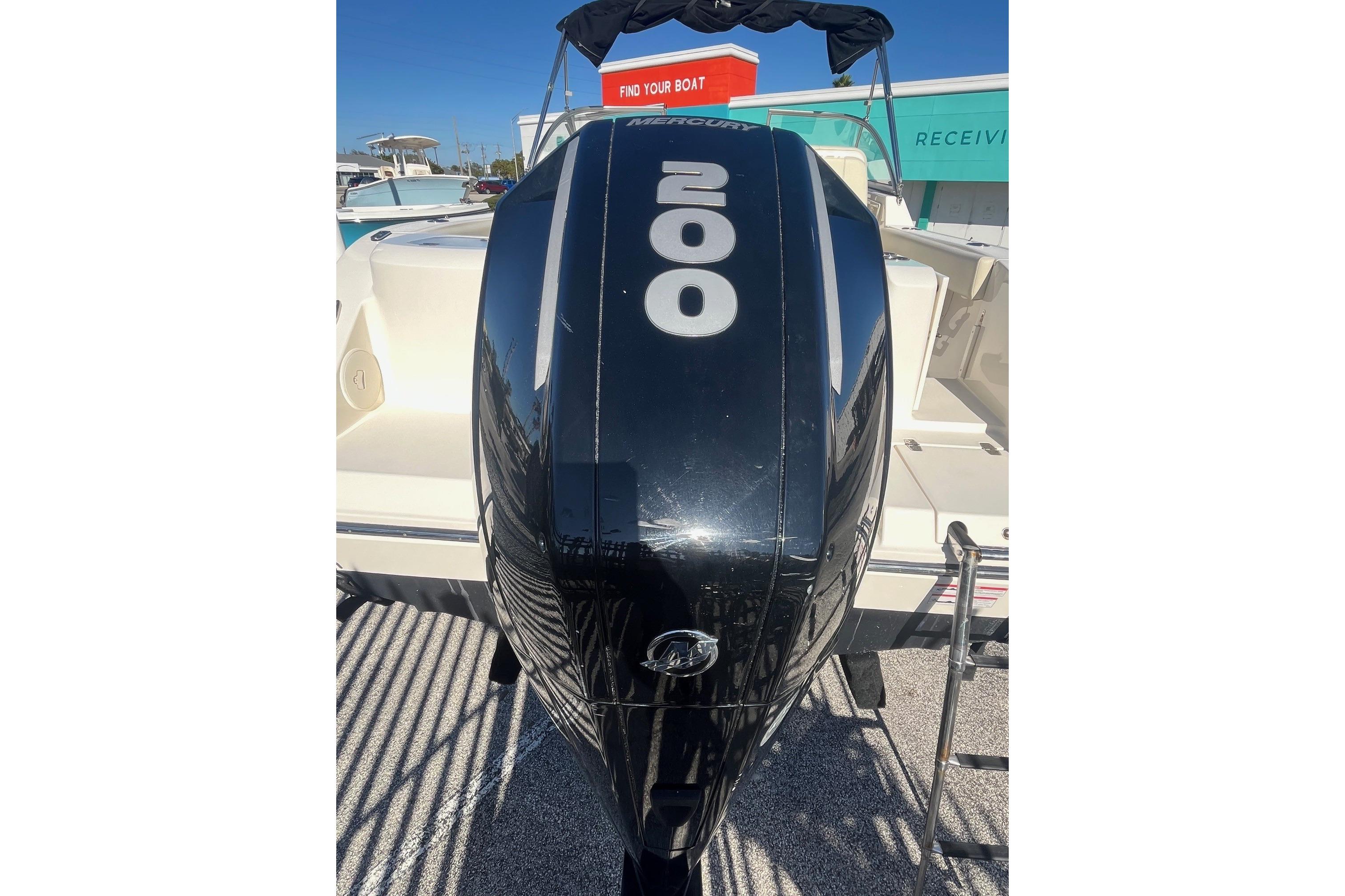 2023 Cobia 220 Dual Console with Mercury 200 outboard engine, docked under clear skies.