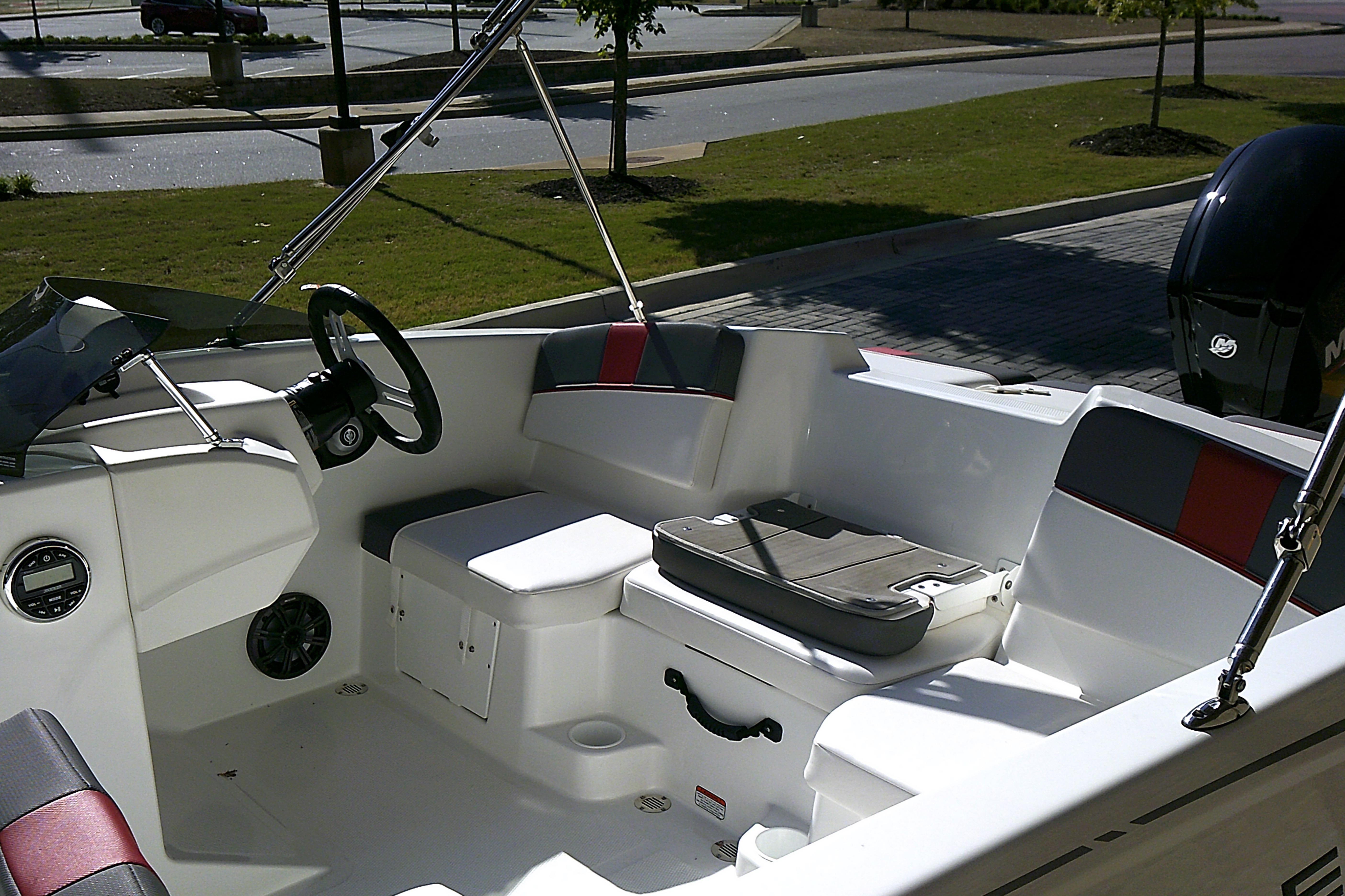 2025 Tahoe T16 boat interior with seating and steering wheel, parked outdoors.