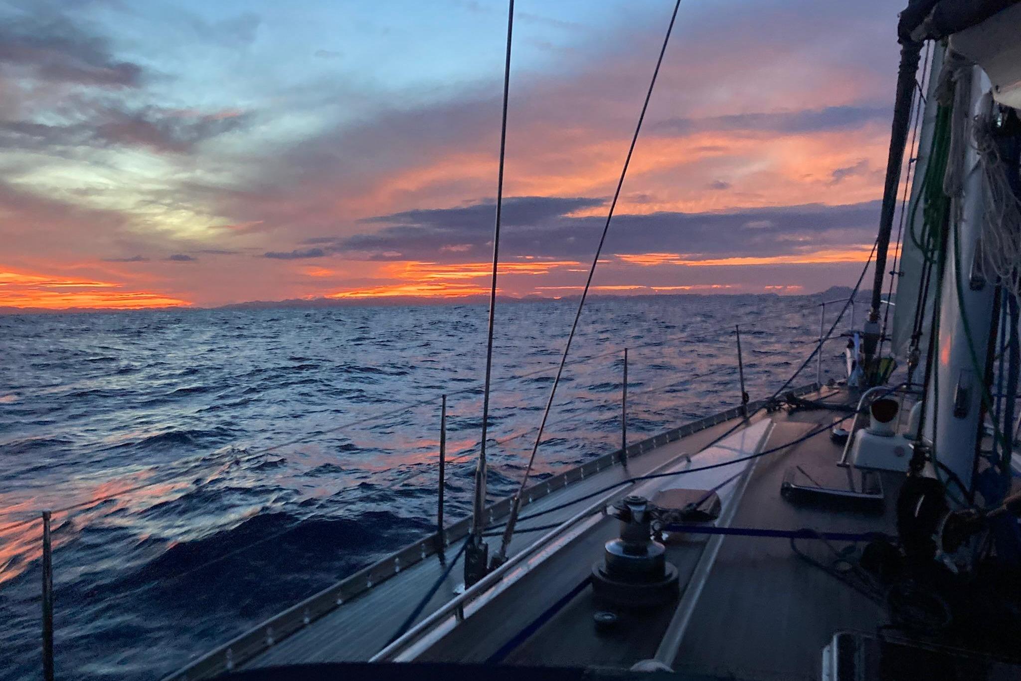 Sailing on a 1992 Nautor Swan 55 yacht at sunset over the ocean.