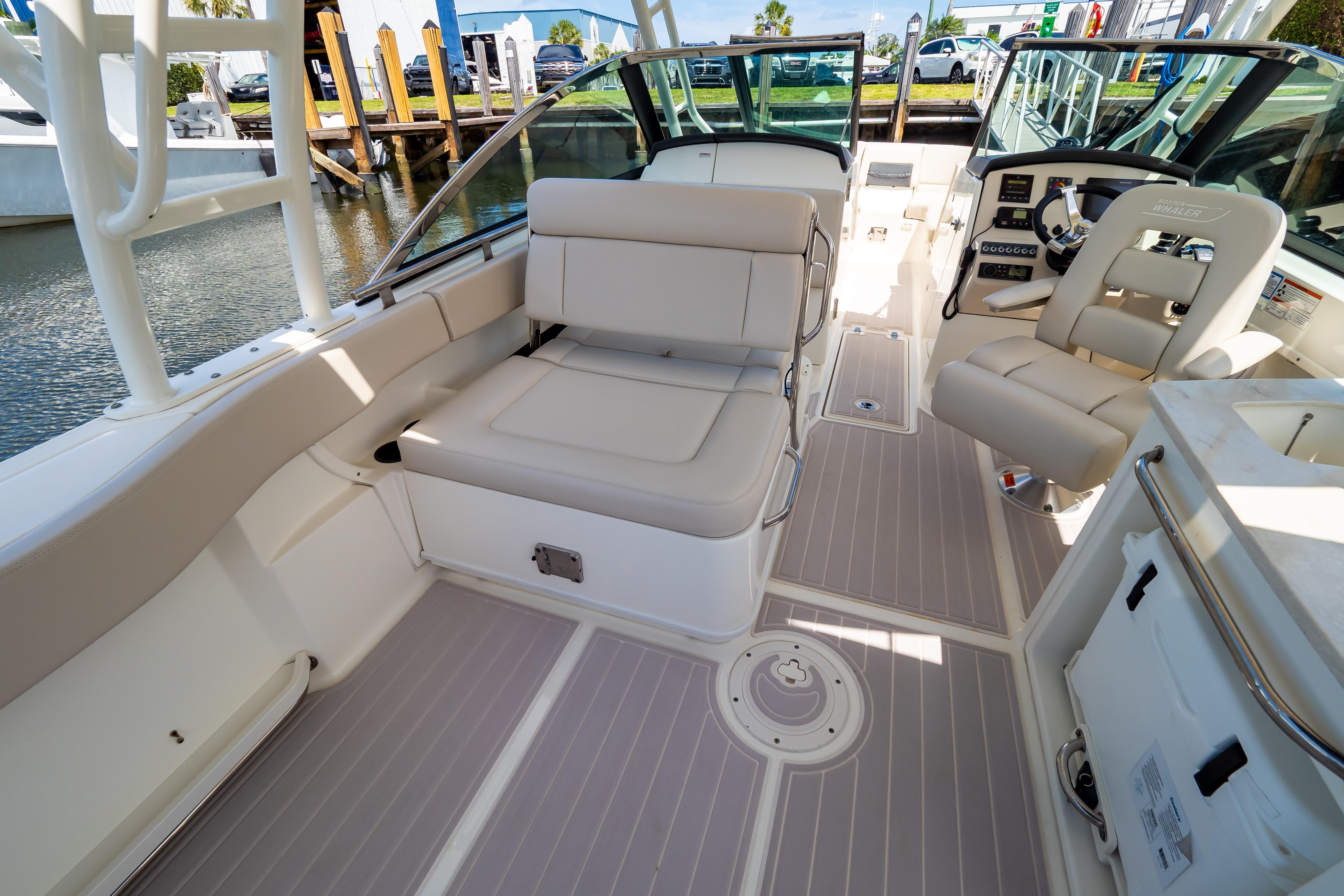 2019 Boston Whaler 270 Vantage boat interior with seating and helm, docked by the water.