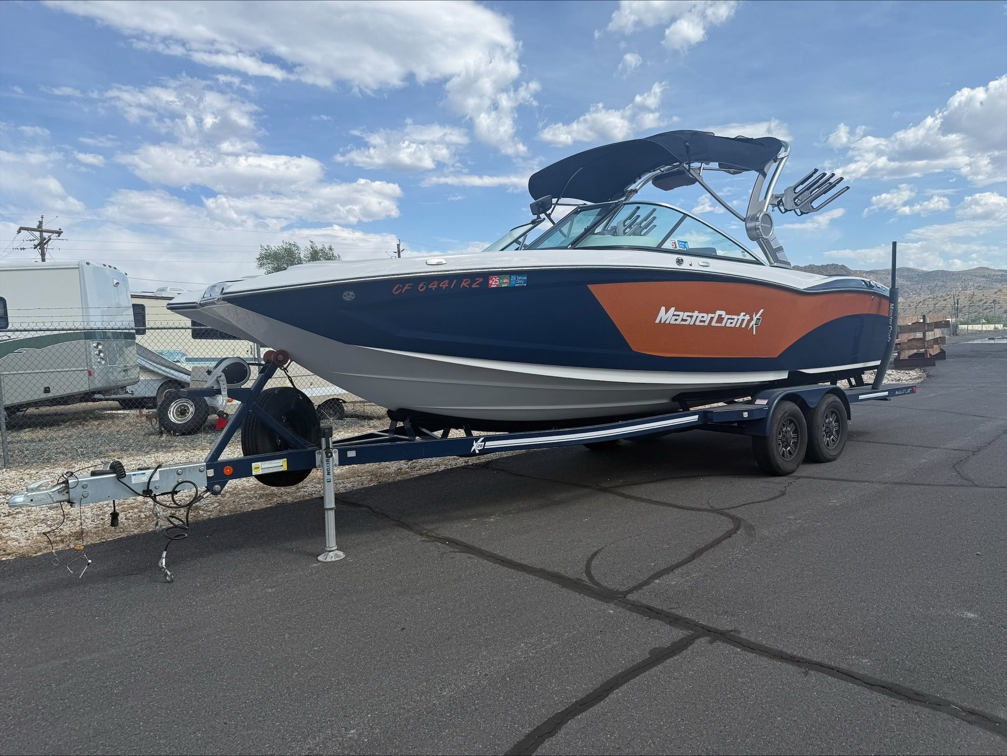 A 2018 MasterCraft X26 boat on a trailer in a parking lot.