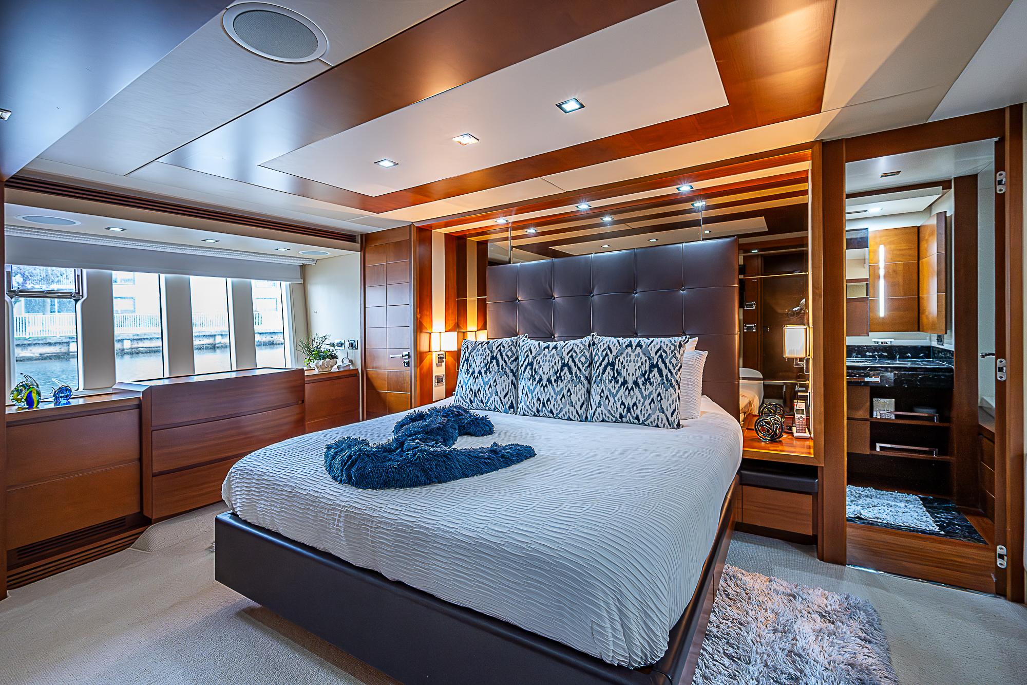 Luxurious bedroom interior of 2011 Azimut 82 yacht with modern design and large windows.