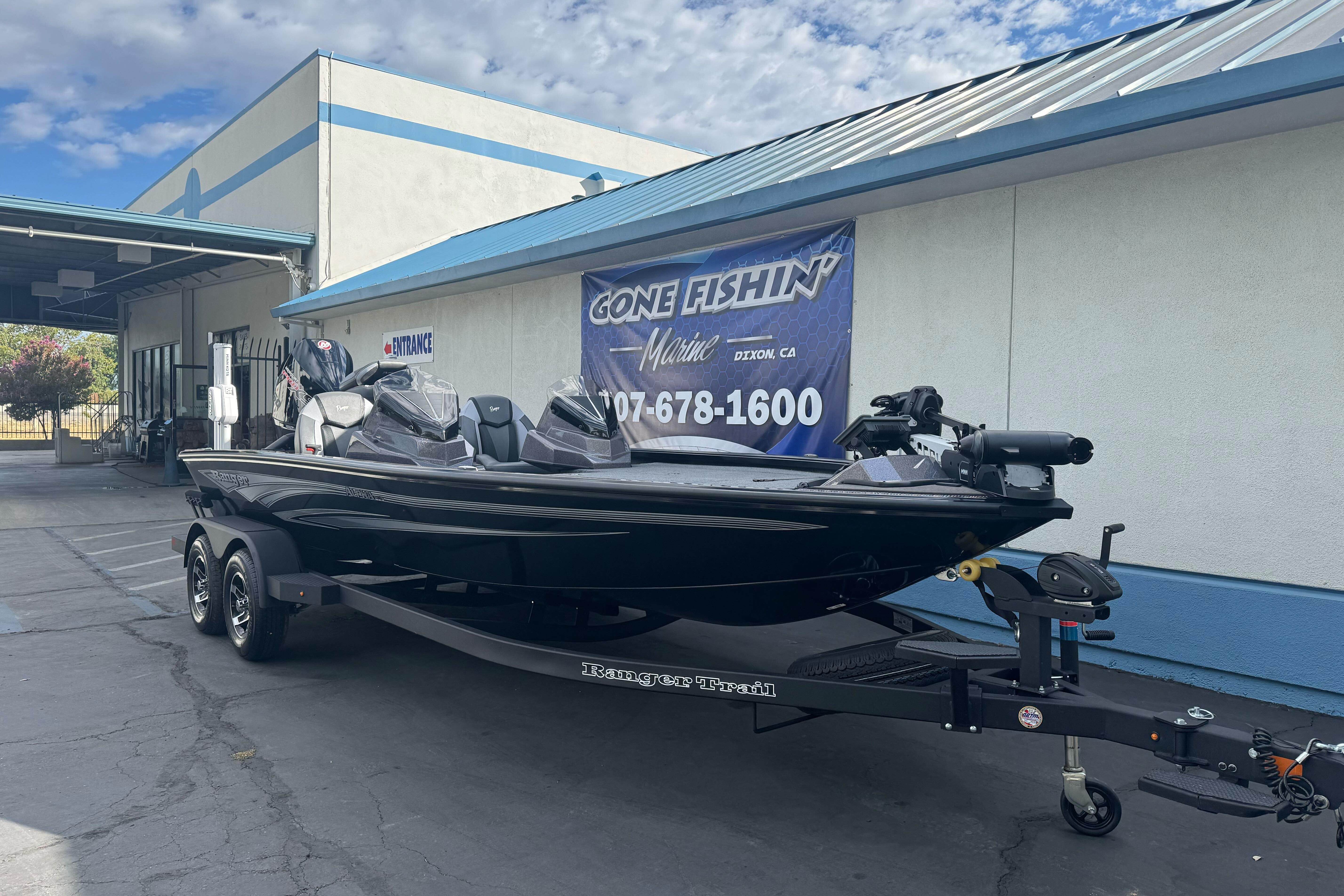 2026 Ranger ALPHA 208 boat on trailer outside dealership, featuring sleek black design.