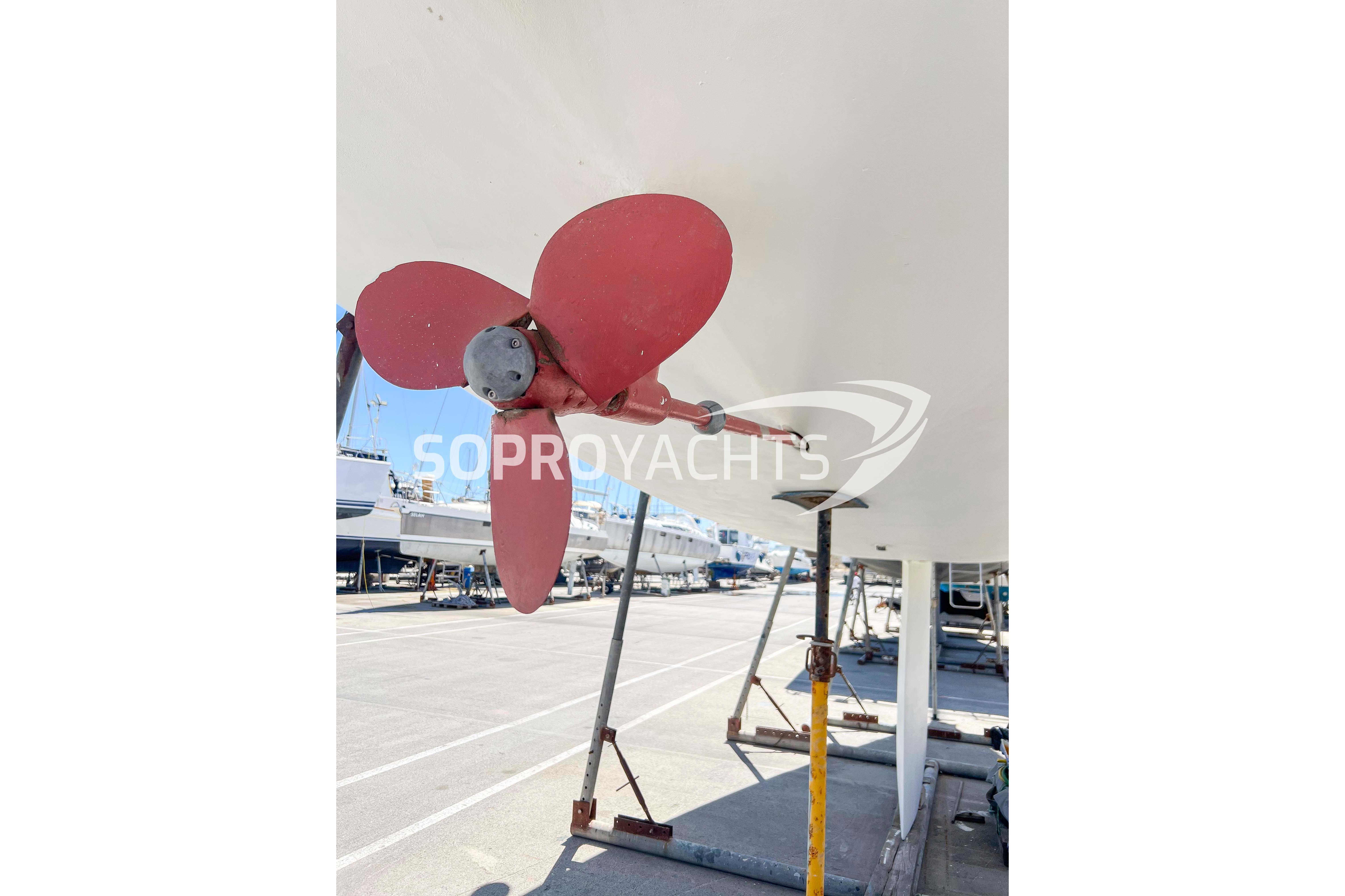 Red propeller of a 1991 Beneteau First 45f5 yacht on dry dock.